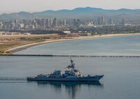 The Arleigh Burke-class guided-missile destroyer USS Mustin (DDG 89) transits San Diego Bay past Point Loma, Feb. 23, 2026. The ship departed Naval Base San Diego and will forward deploy to Yokosuka, Japan, as part of a scheduled rotation of forces in the Pacific. (U.S. Navy photo by Mark D. Faram)