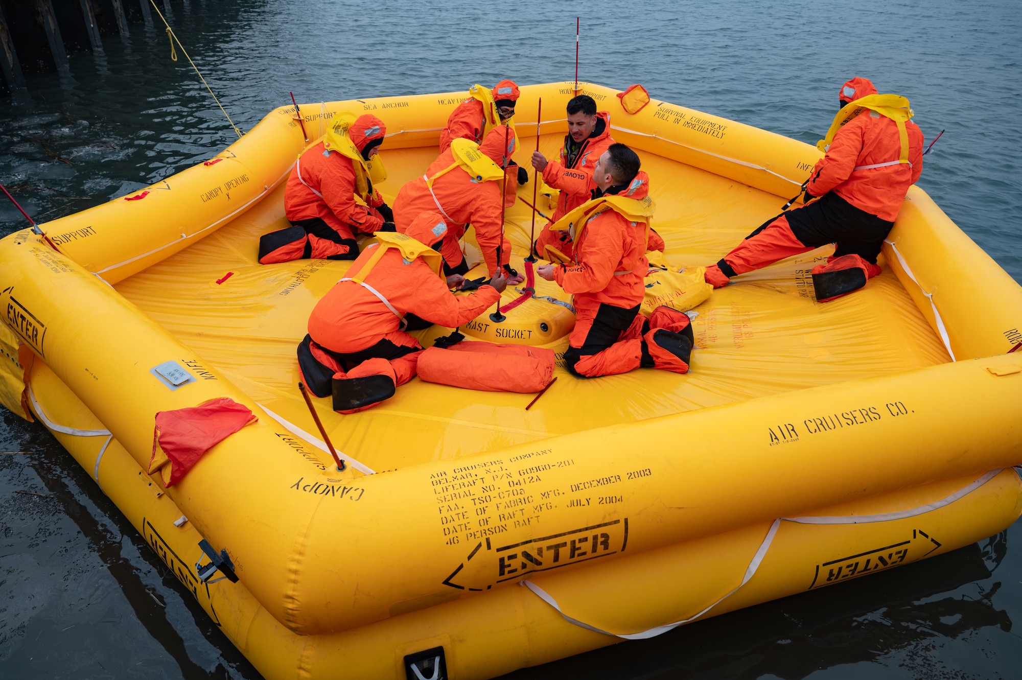 U.S. Air Force Airmen assigned to the 305th Operations Support Squadron Survival, Evasion, Resistance and Escape shop and 305th OSS aircrew flight equipment flight set up a life raft canopy during water survival training at U.S. Coast Guard Station Atlantic City, N.J., Feb. 17, 2026. The canopy protected Airmen from wind, rain and other harsh elements as they completed the multi-day exercise. (U.S. Air Force photo by Airman 1st Class Haeleigh Bayle)