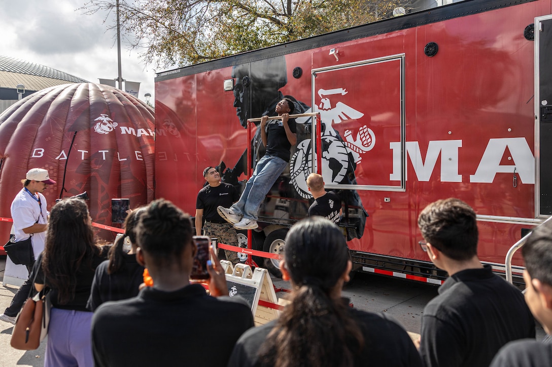 Attendees at the Houston Livestock Show and Rodeo attempt the Marine Corps pull-up bar challenge during Military Appreciation Day in Houston, Texas, March 4, 2026. The challenge gave members of the community an opportunity to test their strength while engaging with Marines and learning about the opportunities in the United States Marine Corps. (U.S. Marine Corps photo by Cpl. Christian Salazar)