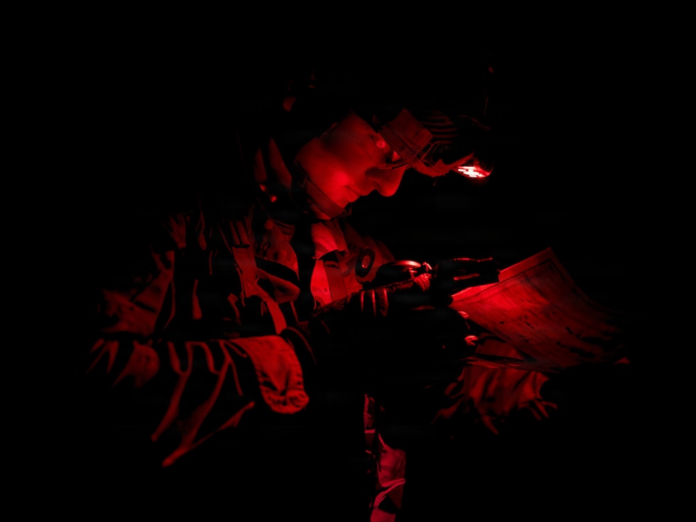 Spc. Ian Glei, a military police officer assigned to the 554th Military Police Company, 709th Military Police Battalion, 18th Military Police Brigade, uses a map and compass during night land navigation as part of the 18th Military Police Brigade Best Squad Competition at U.S. Army Garrison Bavaria, Germany, March 2, 2026.