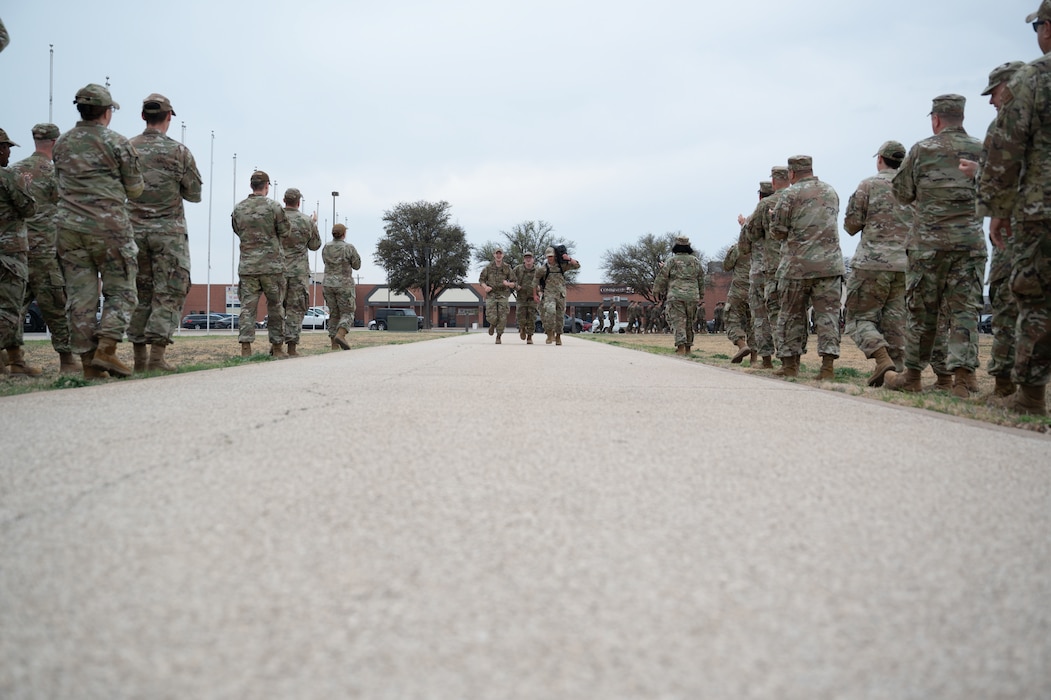 Participants run towards the finish line during the inaugural Noncommissioned Officer Ruck March at Goodfellow Air Force Base, Texas, March 5, 2026. Senior enlisted personnel waited at the end of the ruck to congratulate the new NCOs for finishing the ruck. (U.S. Air Force photo by Senior Airman Brian Lummus)