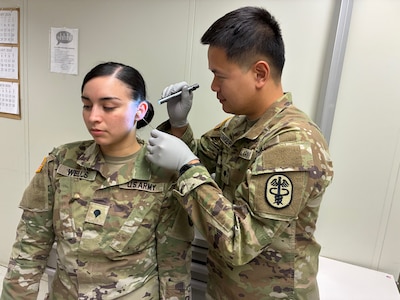 Munson Army Health Center Soldier Spc. Chaiyaporn Charoenput examines fellow Munson Soldier Spc. Dalilah Wells’ ear during a practical exercise during specialized training to earn certification through the Council for Accreditation in Occupational Hearing Conservation at Fort Leonard Wood, Missouri Feb. 26. Charoenput and Wells were two of four Munson Soldiers selected to attend the week-long training.
