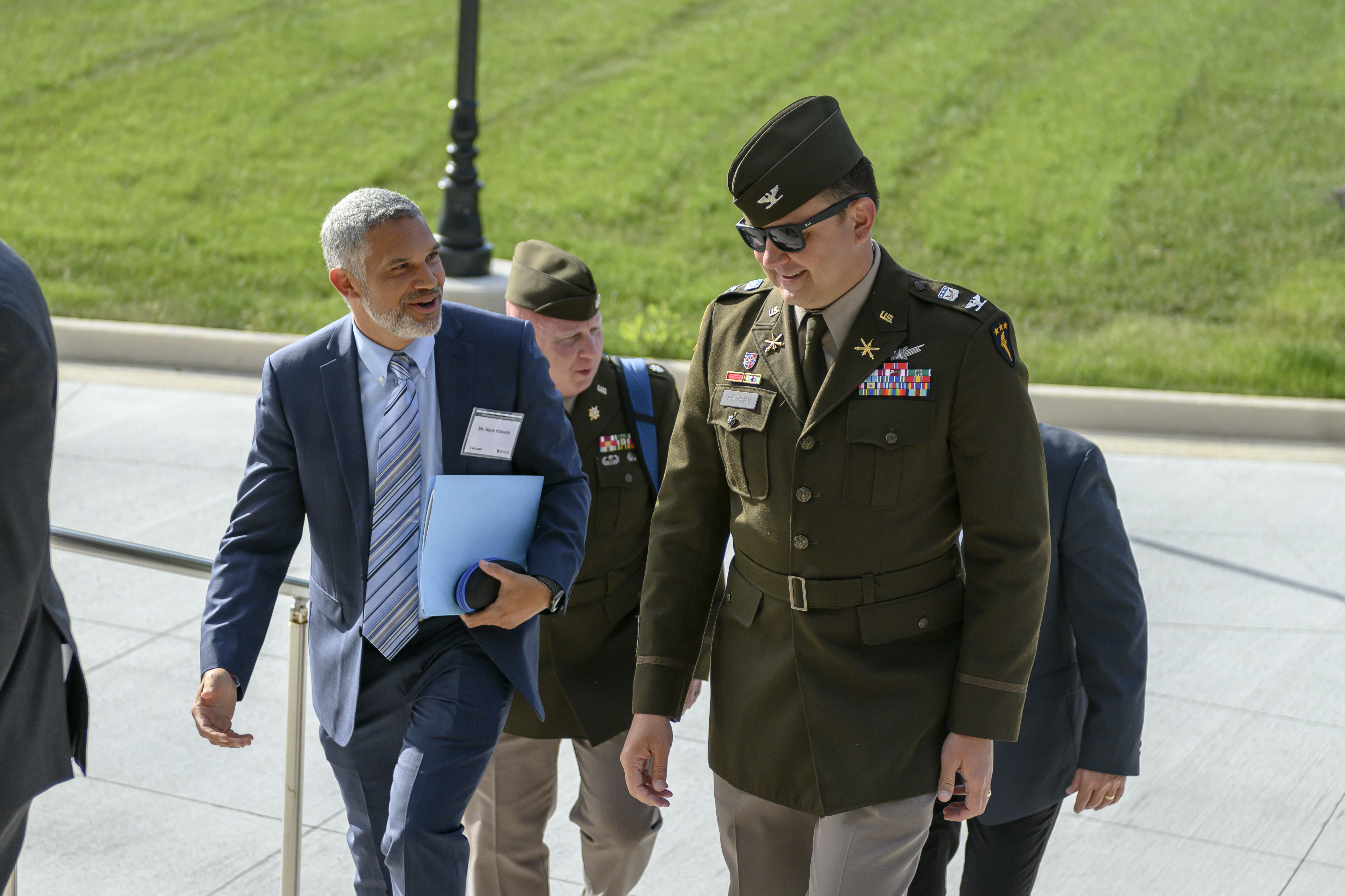 Group of people walking up the steps of root hall. 