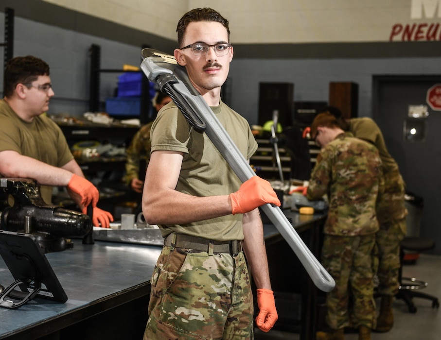 Airman 1st Class Hayden Birt, 55th Maintenance Squadron, holds an extra-large pipe wrench nicknamed "Big Bertha" in the hydraulics shop of the Bennie L. Davis maintenance facility on Offutt Air Force Base, March 5, 2026. (U.S. Air Force photo by Chad Watkins)