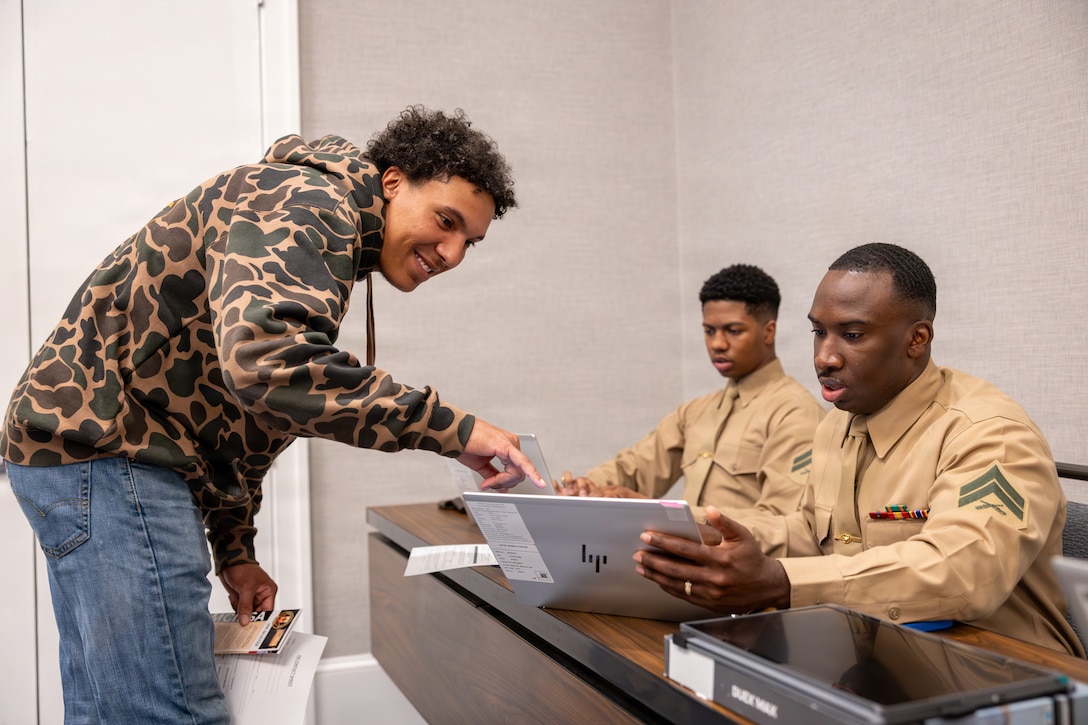U.S. Marine Corps Cpl. Myrick Holloman, right, an administrative clerk with Force Headquarters Group, Marine Forces Reserve, helps an Individual Ready Reserve Marine with administrative work during the Individual Ready Reserve muster at Arlington, Virginia, March 7, 2026. Marine Corps Individual Reserve Support Activity conducts administrative screenings of IRR Marines to ensure readiness to augment and reinforce the active component. (U.S. Marine Corps photo by Sgt. Emely Gonzalez)