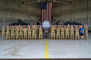 U.S. Air Force Airmen assigned to the 174th Attack Wing, New York Air National Guard, pose for a group photo during exercise Sentry South 26-2 in Gulfport, Mississippi, March 3, 2026. Sentry South 26-2 is a large force employment exercise focused on major combat operations and joint maritime opportunities in a contested or degraded operational environment. Sentry South 26-2 applies joint and combined warfighting doctrine against realistic and robust enemy integrated threat systems, all while under safe and controlled conditions. (U.S. Air National Guard photo by Staff Sgt. Dylan McCrink)