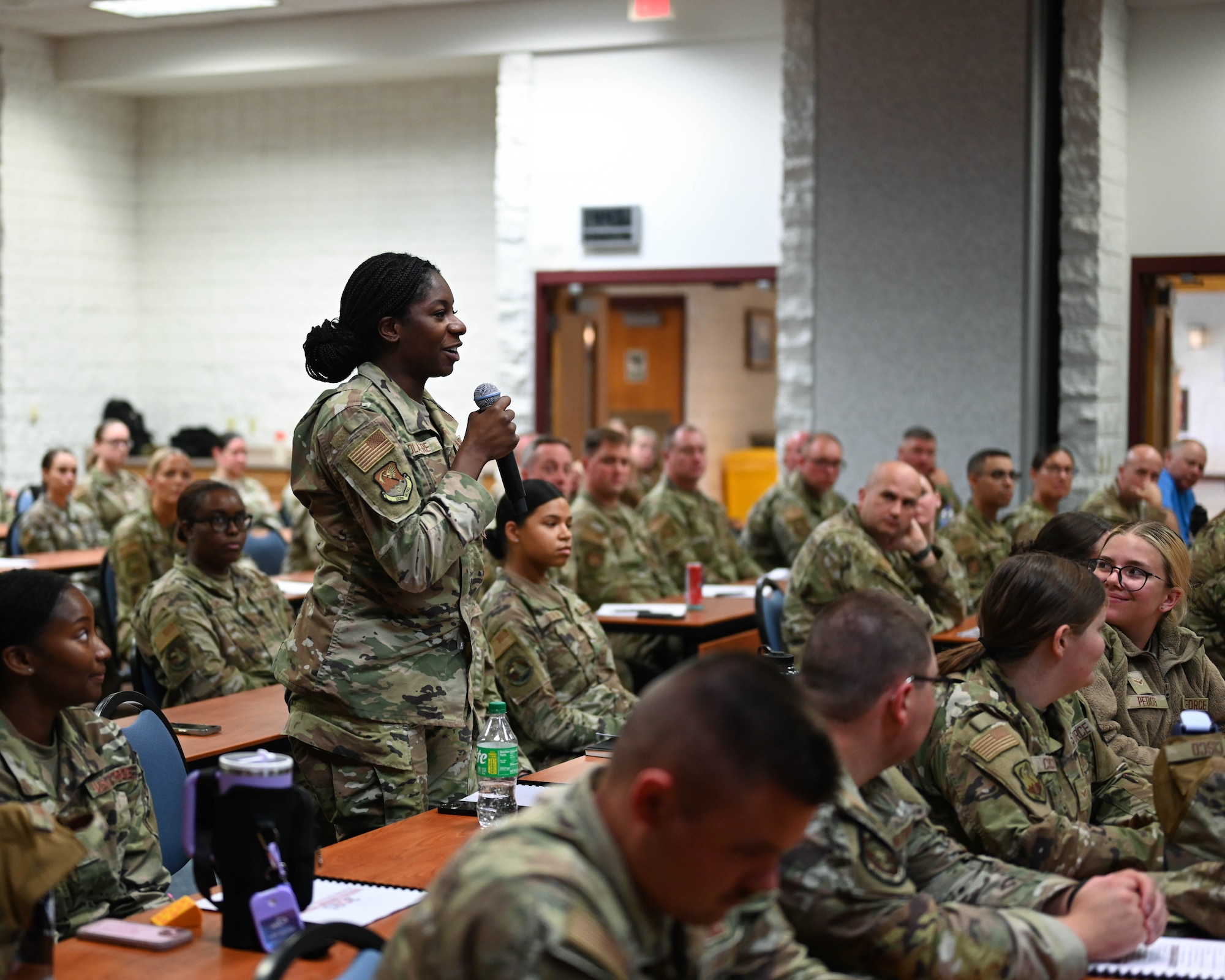 Volk Field CRTC, WI - U.S. Air Force Airman First Class Debbie Olalere, with the 183d Logistic Readiness Squadron, Illinois Air National Guard, asks questions during a question and answer portion of a presentation by Command Chief of the Air National Guard Joshua Moore at the 2025 Enlisted Leadership Workshop on July 23, 2025
