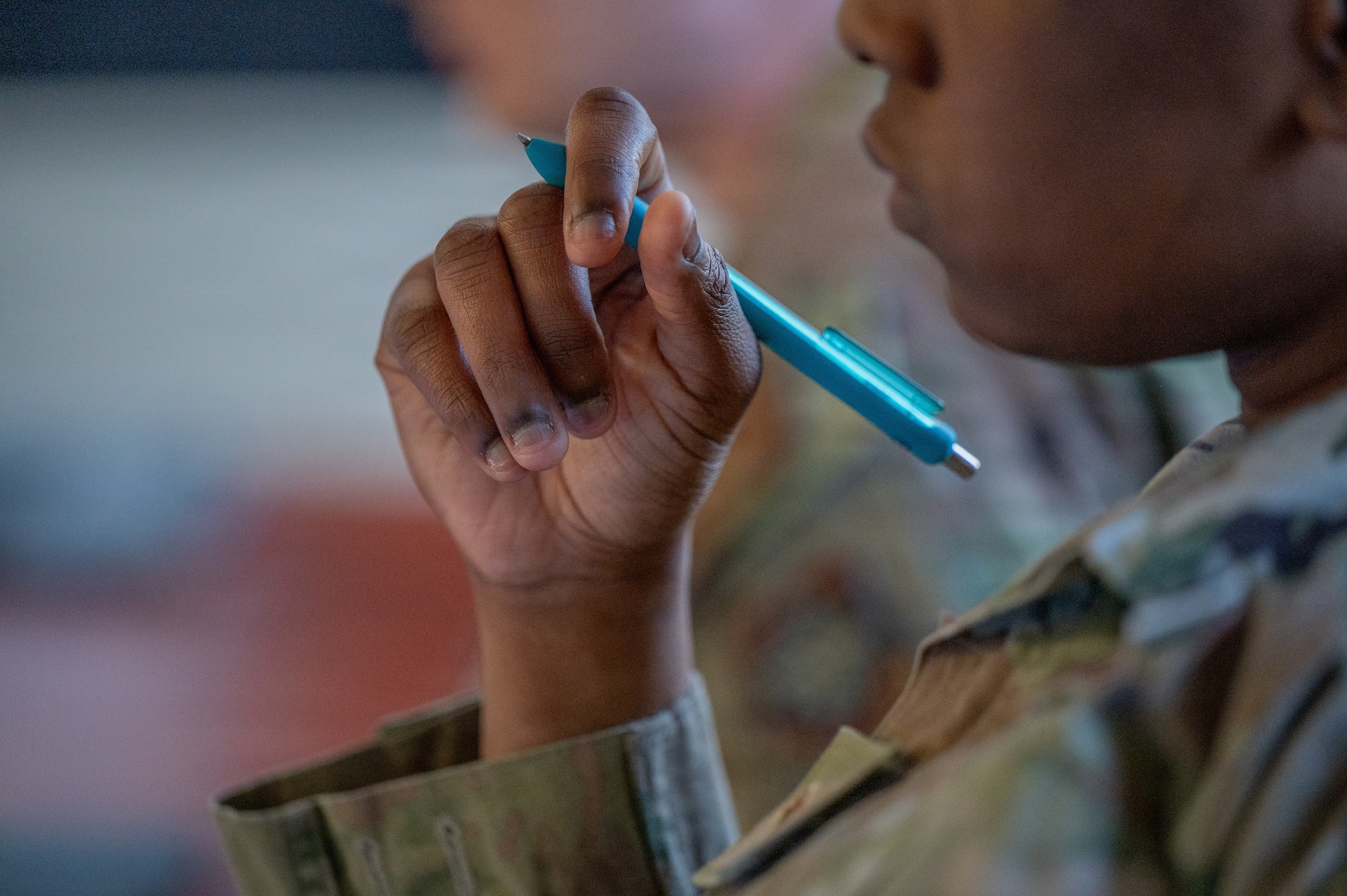 A student attending Airman Leadership School holds their pen during a group discussion at Maxwell Air Force Base