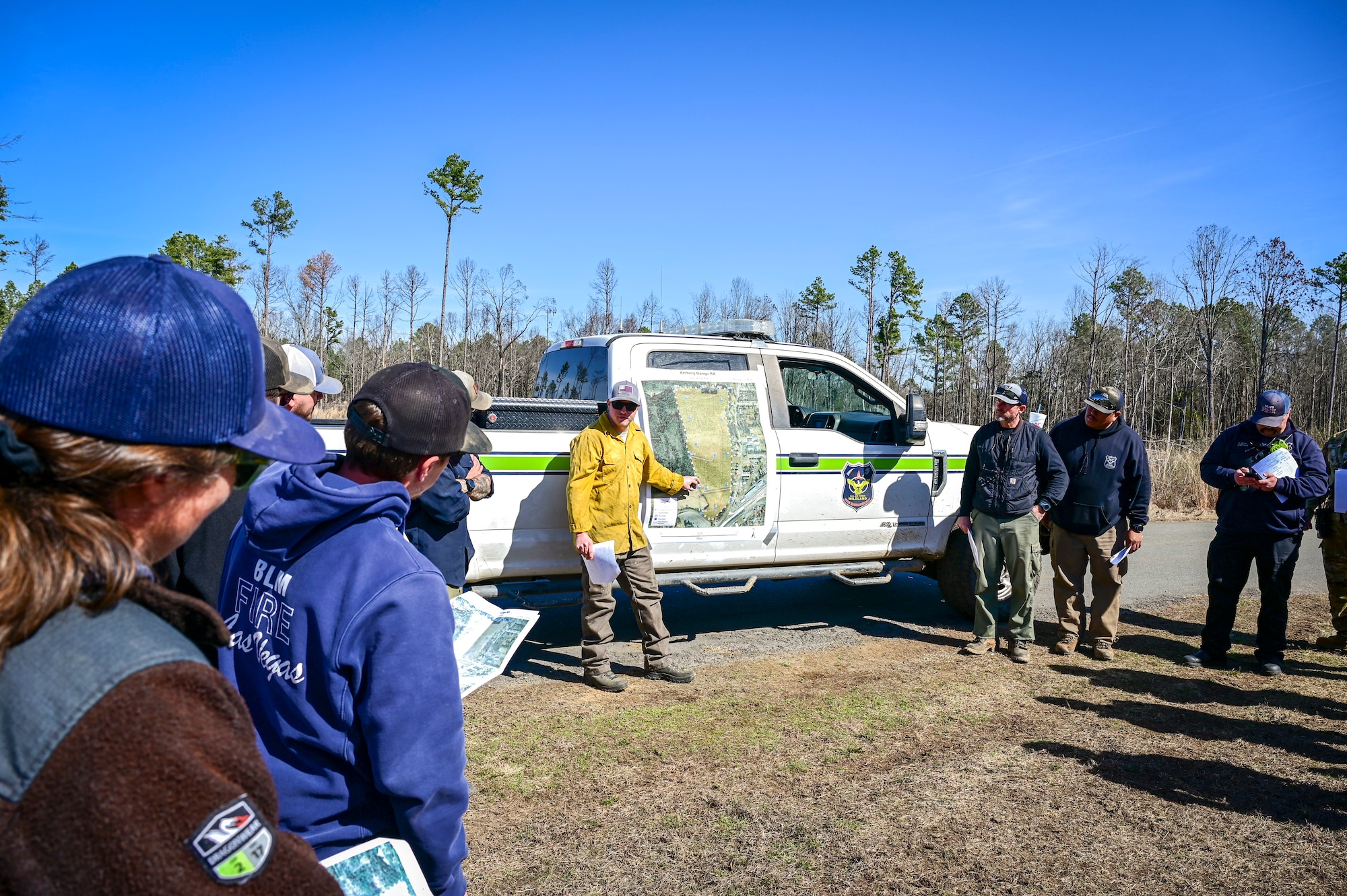 A wildland fire program coordinator, briefs wildland fire personnel prior to a prescribed burn.