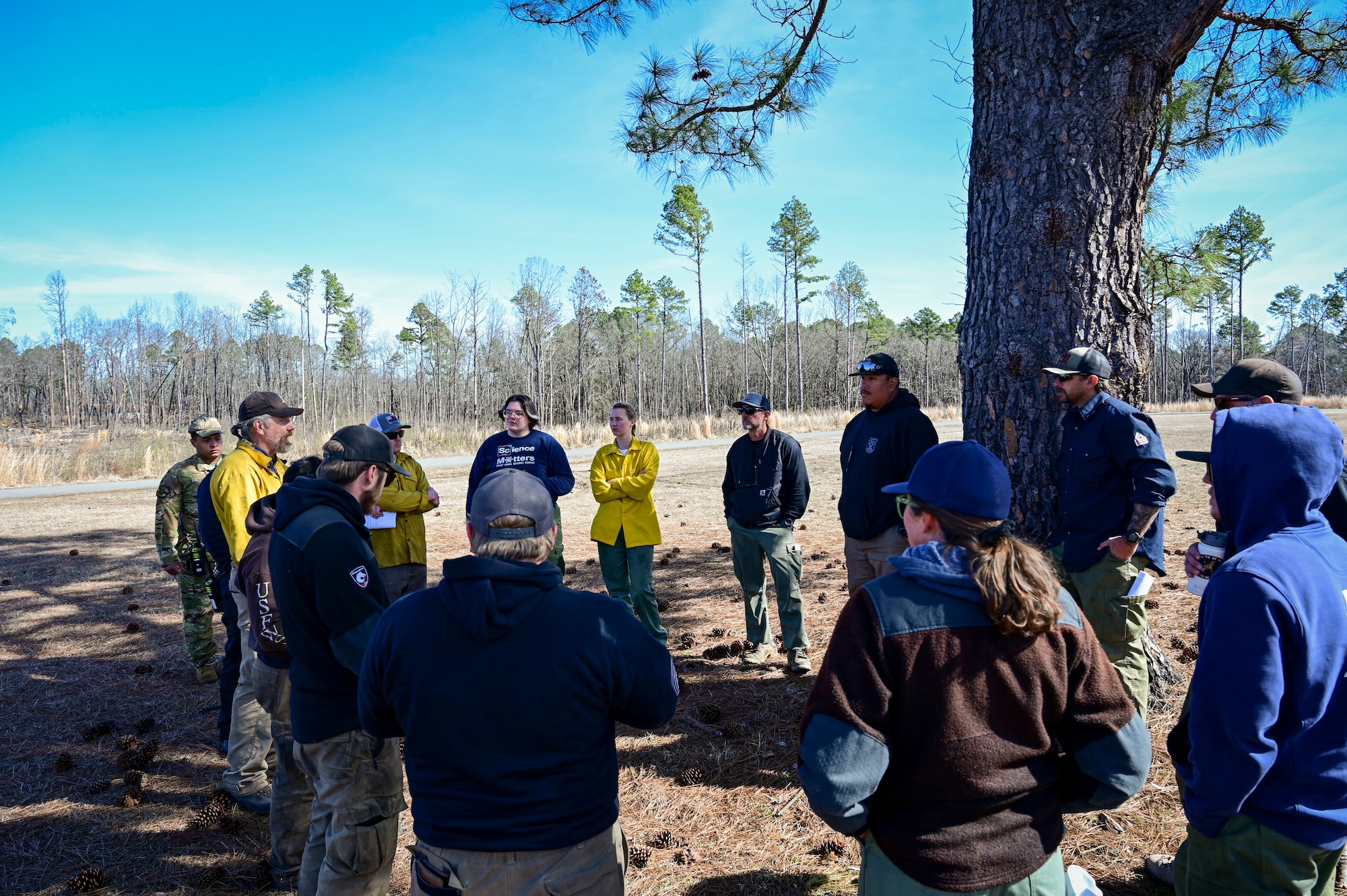 Wildland fire personnel gather for an after- action review before operations during a prescribed burn.