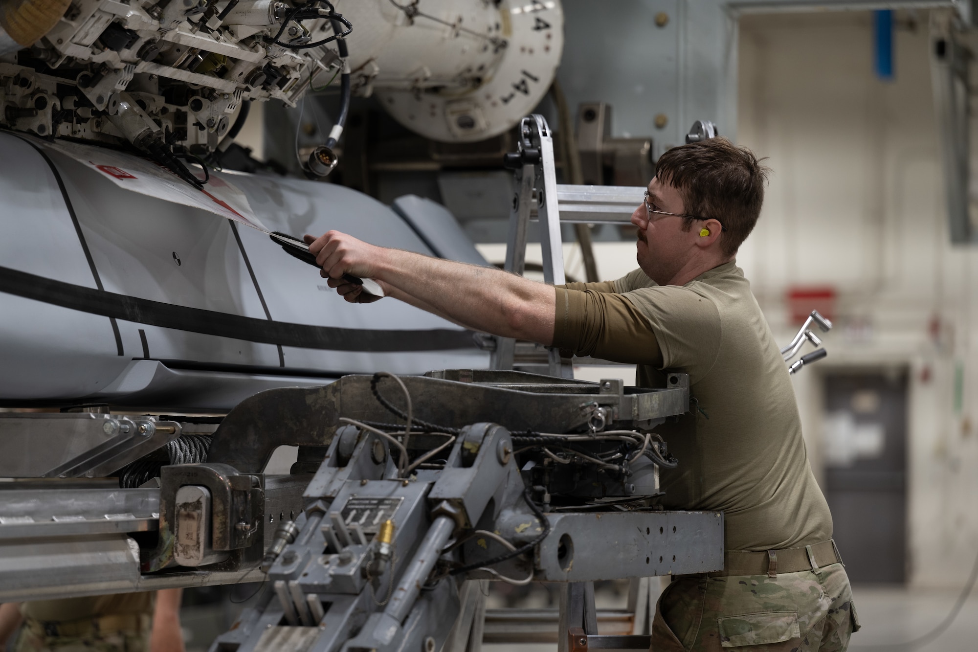 U.S. Air Force Senior Airman Steven Hoyer, 7th Munitions Squadron armament maintenance member, conducts the process of loading a Joint Air-to-Surface Standoff Missile at Dyess Air Force Base, Texas, Feb. 14, 2026. Launcher Load Frames were used for the first time during the JASSM loadout, providing 7th MUNS Airmen valuable experience to improve configuration times on the flightline. (U.S. Air Force photo by Airman 1st Class Caleb Schellenberg)