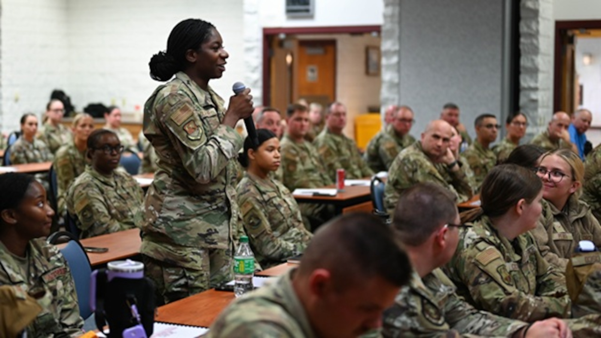 Volk Field CRTC, WI - U.S. Air Force Airman First Class Debbie Olalere, with the 183d Logistic Readiness Squadron, Illinois Air National Guard, asks questions during a question and answer portion of a presentation by Command Chief of the Air National Guard Joshua Moore at the 2025 Enlisted Leadership Workshop on July 23, 2025,
