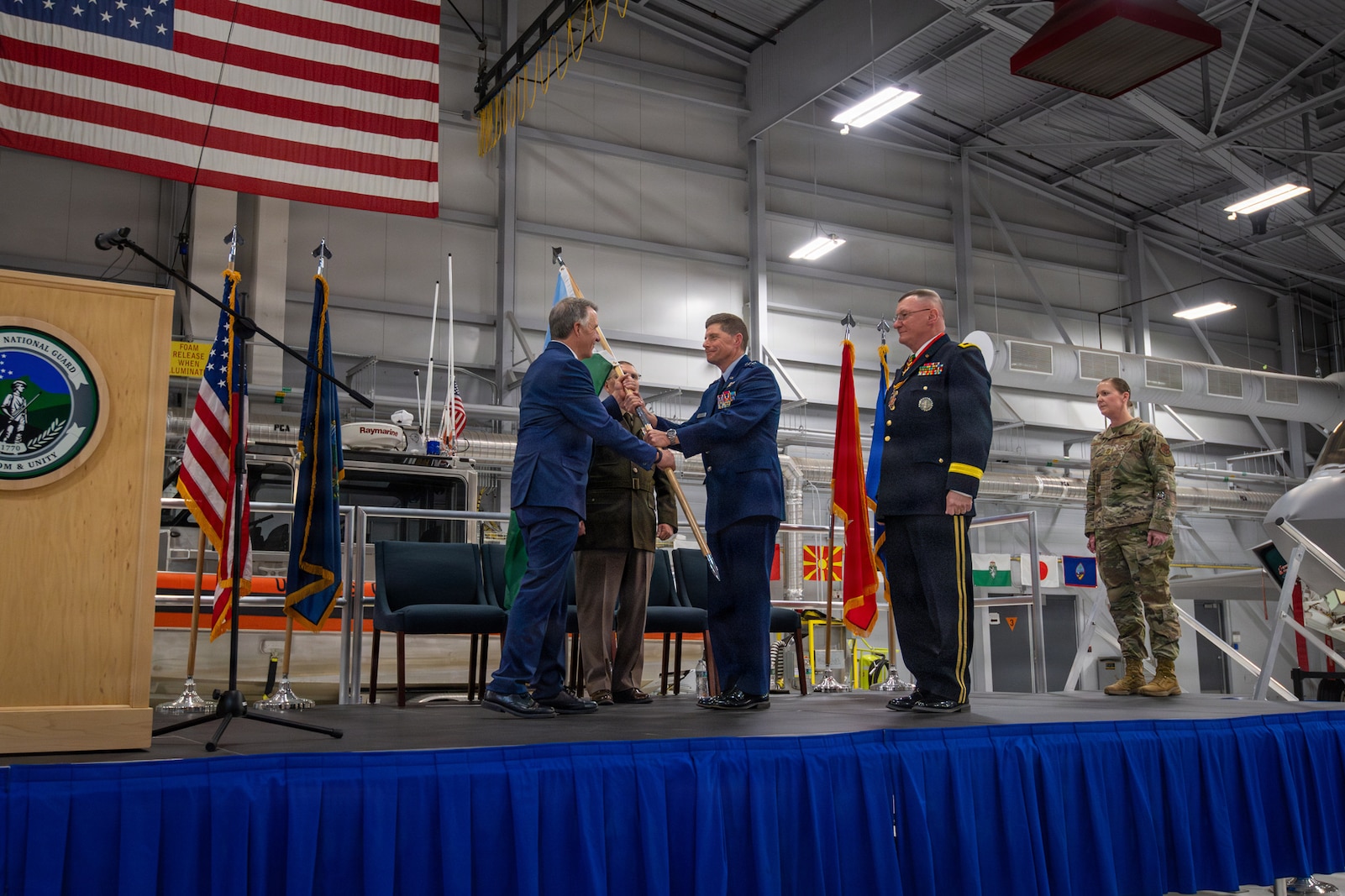 Photo of Phil Scott, Vermont's Governor, presenting the guidon of the Vermont National Guard to U.S. Air Force Maj. Gen. Henry Harder Jr., Adjutant General of the Vermont National Guard, during a change of command ceremony at the Vermont Air National Guard Base, South Burlington, Vermont, March 7, 2026.