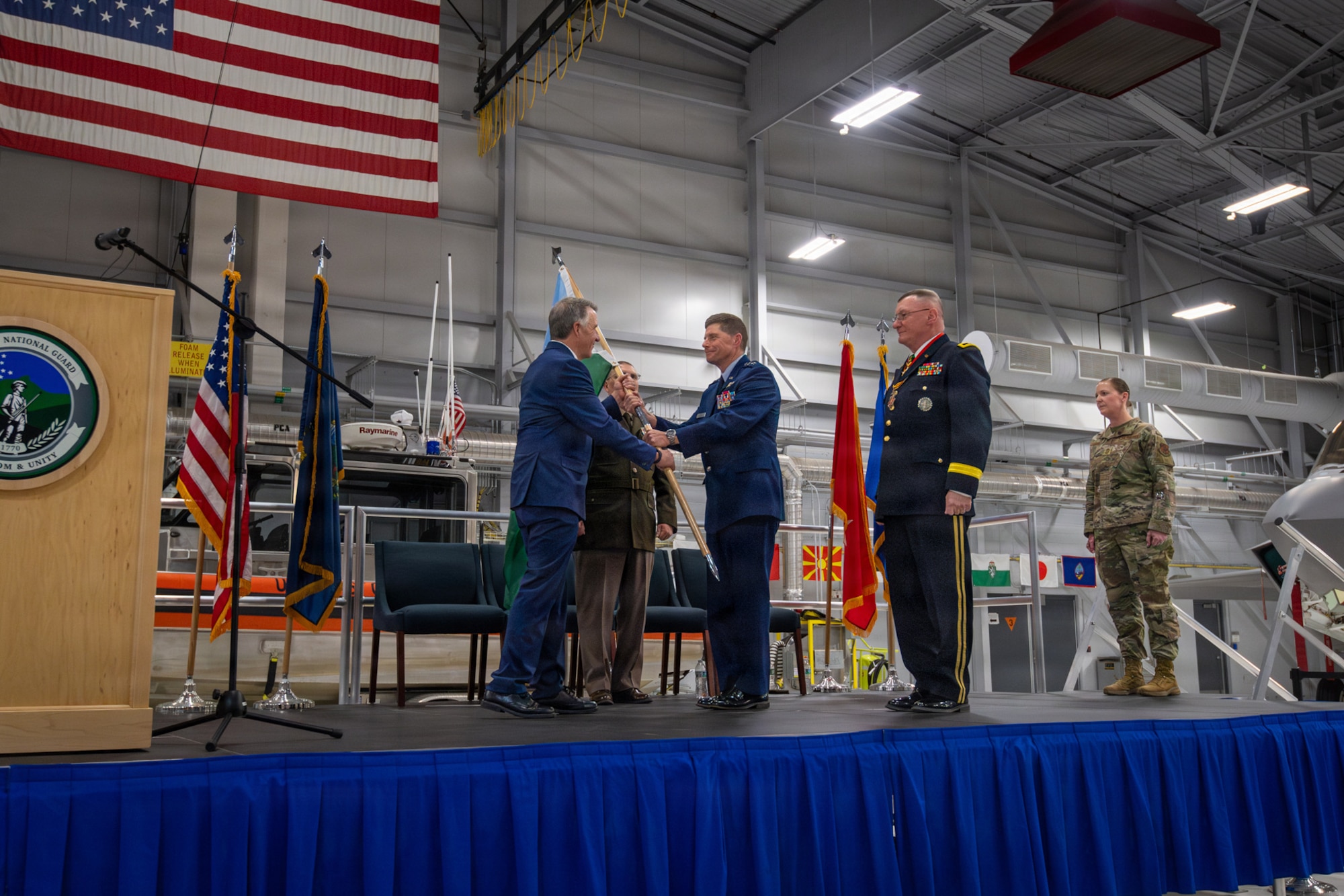 Photo of Phil Scott, Vermont's Governor, presenting the guidon of the Vermont National Guard to U.S. Air Force Maj. Gen. Henry Harder Jr., Adjutant General of the Vermont National Guard, during a change of command ceremony at the Vermont Air National Guard Base, South Burlington, Vermont, March 7, 2026.