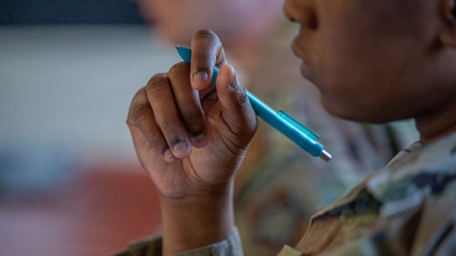 A student attending Airman Leadership School holds their pen during a group discussion at Maxwell Air Force Base, Alabama, Feb. 5, 2026. The multi-week course blends classroom instruction with practical leadership scenarios to prepare Airmen for supervisory roles. (U.S. Air Force photo by Senior Airman Mikayla Cardona