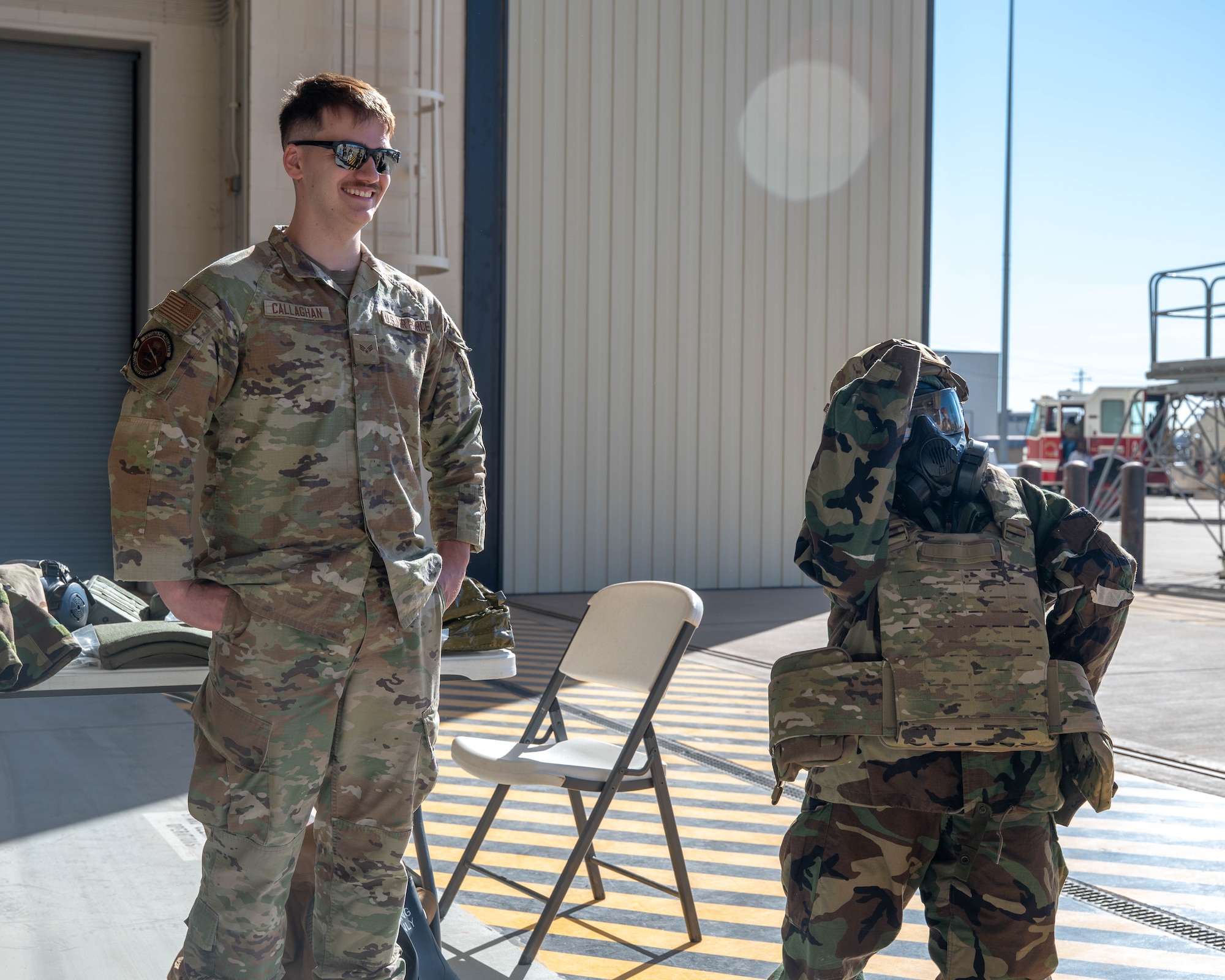 U.S. Air Force Senior Airman Donovan Callaghan, 7th Logistics Readiness Squadron individual protective equipment technician, stands with a student trying on body armor and chemical protective gear during a career fair at Dyess Air Force Base, Texas, Feb. 26, 2026. The event invited students from the local area on to the installation to learn about career opportunities available in the Air Force. (U.S. Air Force photo by Airman 1st Class William Neal)