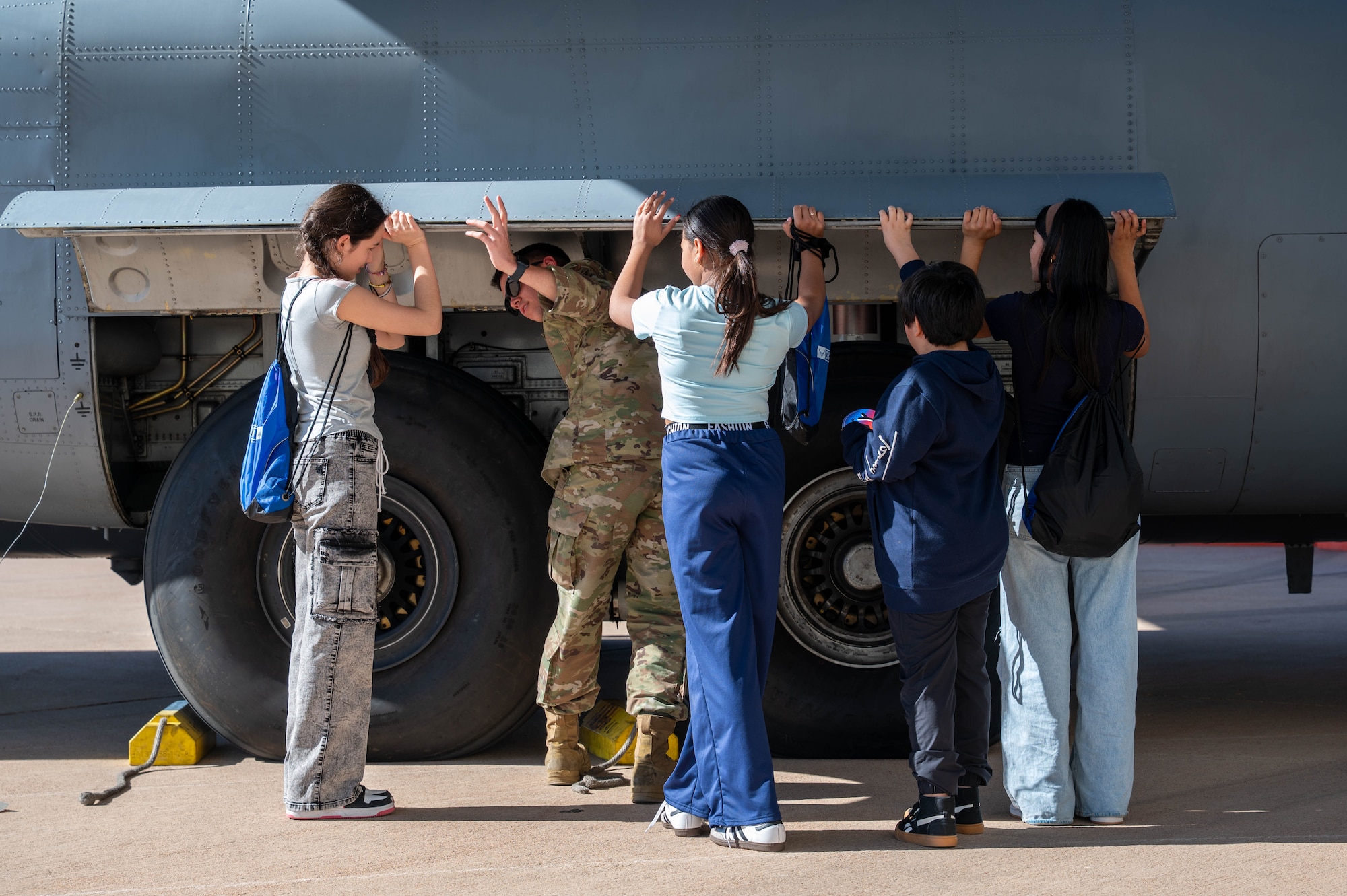A U.S. Airman assigned to the 317th Airlift Wing showcases C-130J Super Hercules landing gear to students during a career fair at Dyess Air Force Base, Texas, Feb. 26, 2026. The students received hands-on experience while learning about the aircraft’s components, operations and mission sets. (U.S. Air Force photo by Airman 1st Class William Neal)