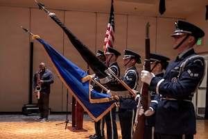 a group of people stand on a stage and hold flags