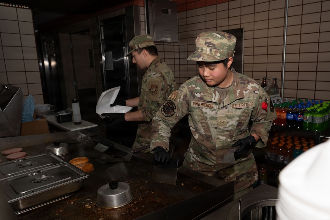 U.S. Air Force Airman 1st Class Kornkanok Pinvanichkul (right) and Airman Braken Guidry, 354th Force Support Squadron food service journeymen, clean and prepare meals in the dining facility kitchen at Eielson Air Force Base, Alaska, March 5, 2026.
