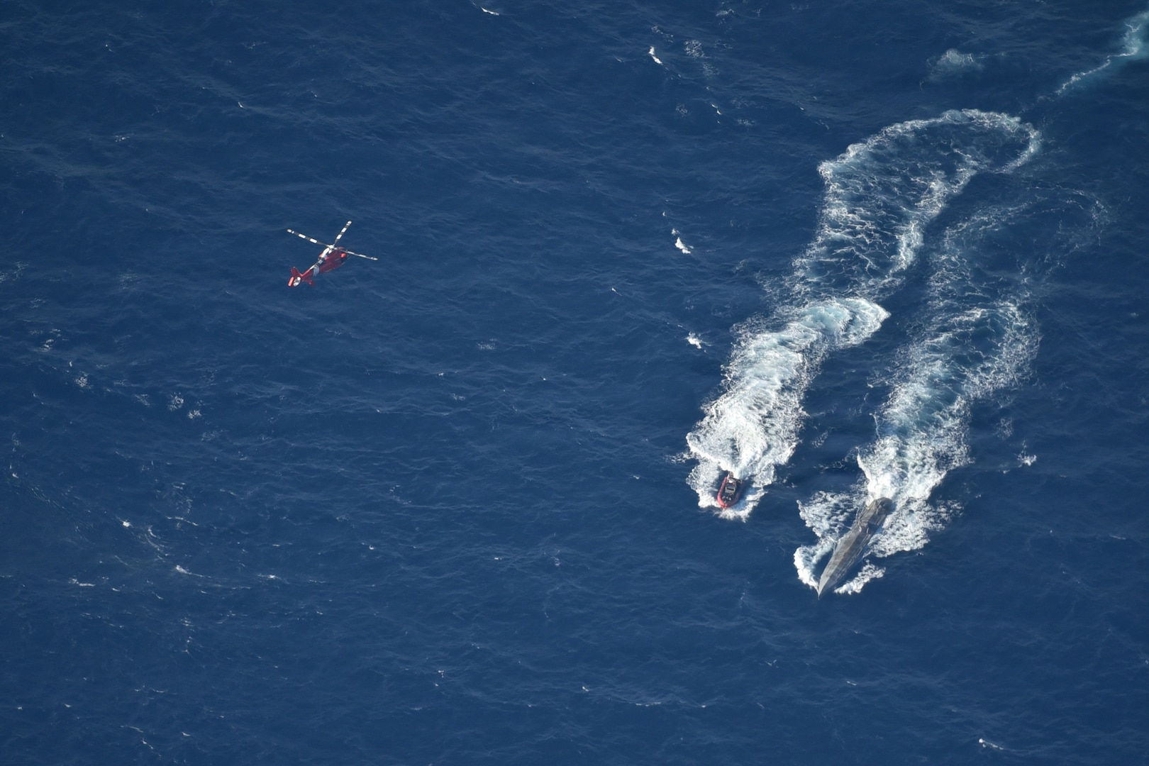 A U.S. Navy P-3 Orion oversees a HITRON MH-65 Dolphin and Coast Guard Cutter Forward Over-the-Horizon boat on scene with a Self-Propelled Semi-Submersible in the Eastern Pacific Ocean, February 24, 2026. (U.S. Navy courtesy photo)