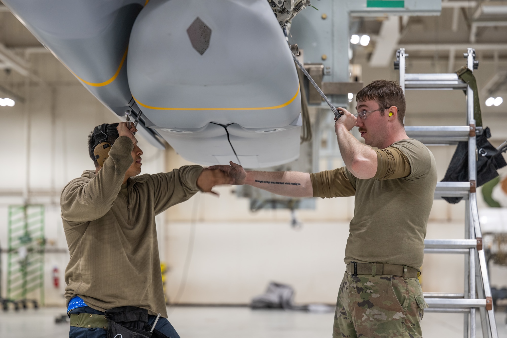 U.S. Air Force Staff Sgt. Heriberto Perez, (left), 7th Munitions Squadron armament maintenance supervisor, and Senior Airman Steven Hoyer, 7th MUNS  armament maintenance member, load a Joint Air-to-Surface Standoff Missile at Dyess Air Force Base, Texas, Feb. 14, 2026. JASSM is a 2,000 pound-class precision cruise missile capable of striking targets from extended ranges outside of enemy air defenses. (U.S. Air Force photo by Airman 1st Class Caleb Schellenberg)