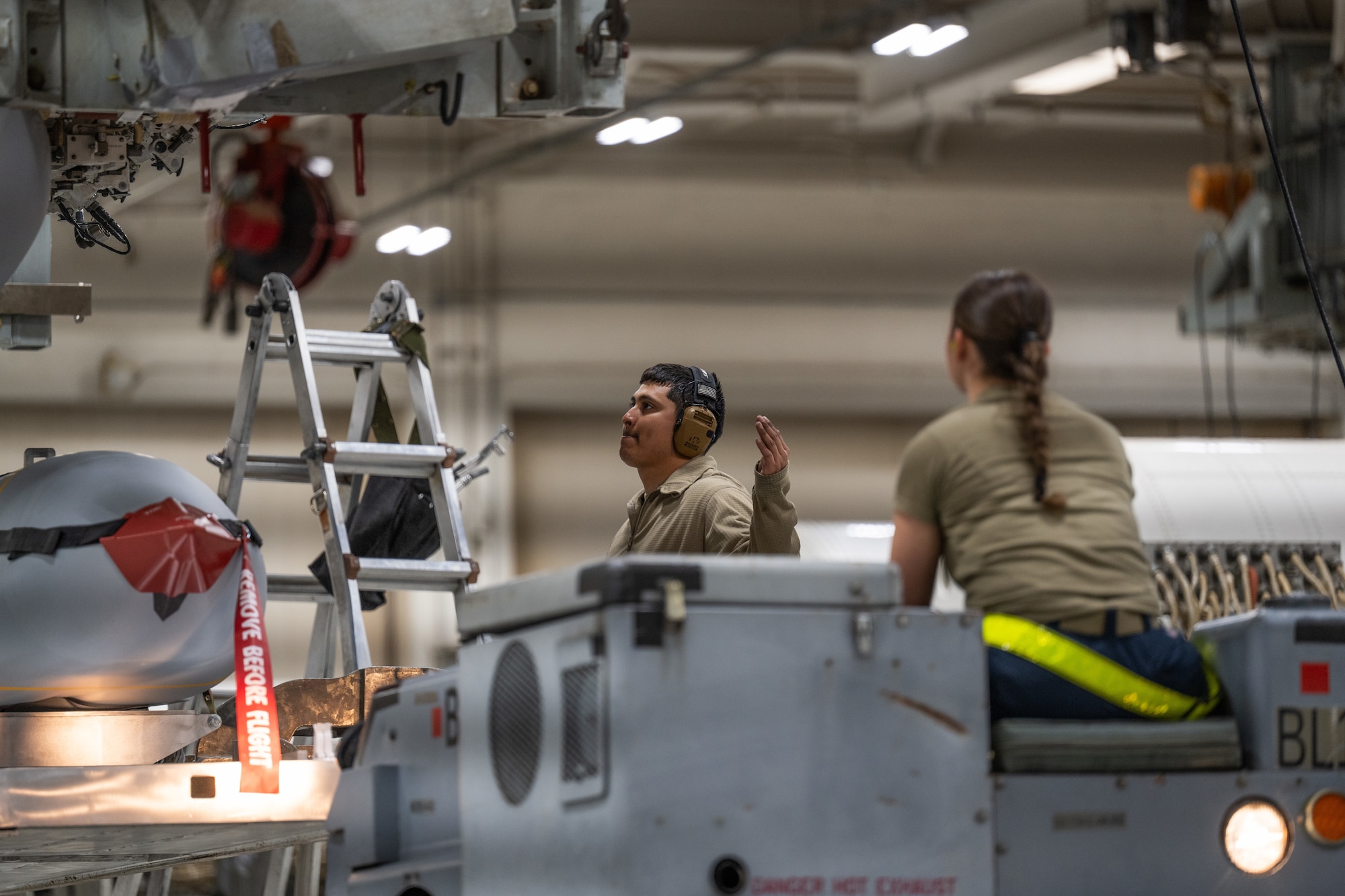 U.S. Air Force Staff Sgt. Heriberto Perez, 7th Munitions Squadron armament maintenance supervisor, left, and Airman 1st Class Maya Roberto, 7th MUNS armament maintenance member, position a Joint Air-to-Surface Standoff Missile to be loaded onto a B-1B Lancer using a  Launcher Load Frame at Dyess Air Force Base, Texas, Feb. 14, 2026. From controlled storage to final aircraft loading, munitions Airmen ensure each weapon meets strict standards that enable the Air Force’s ability to deliver precision strike capabilities. (U.S. Air Force photo by Airman 1st Class Caleb Schellenberg)