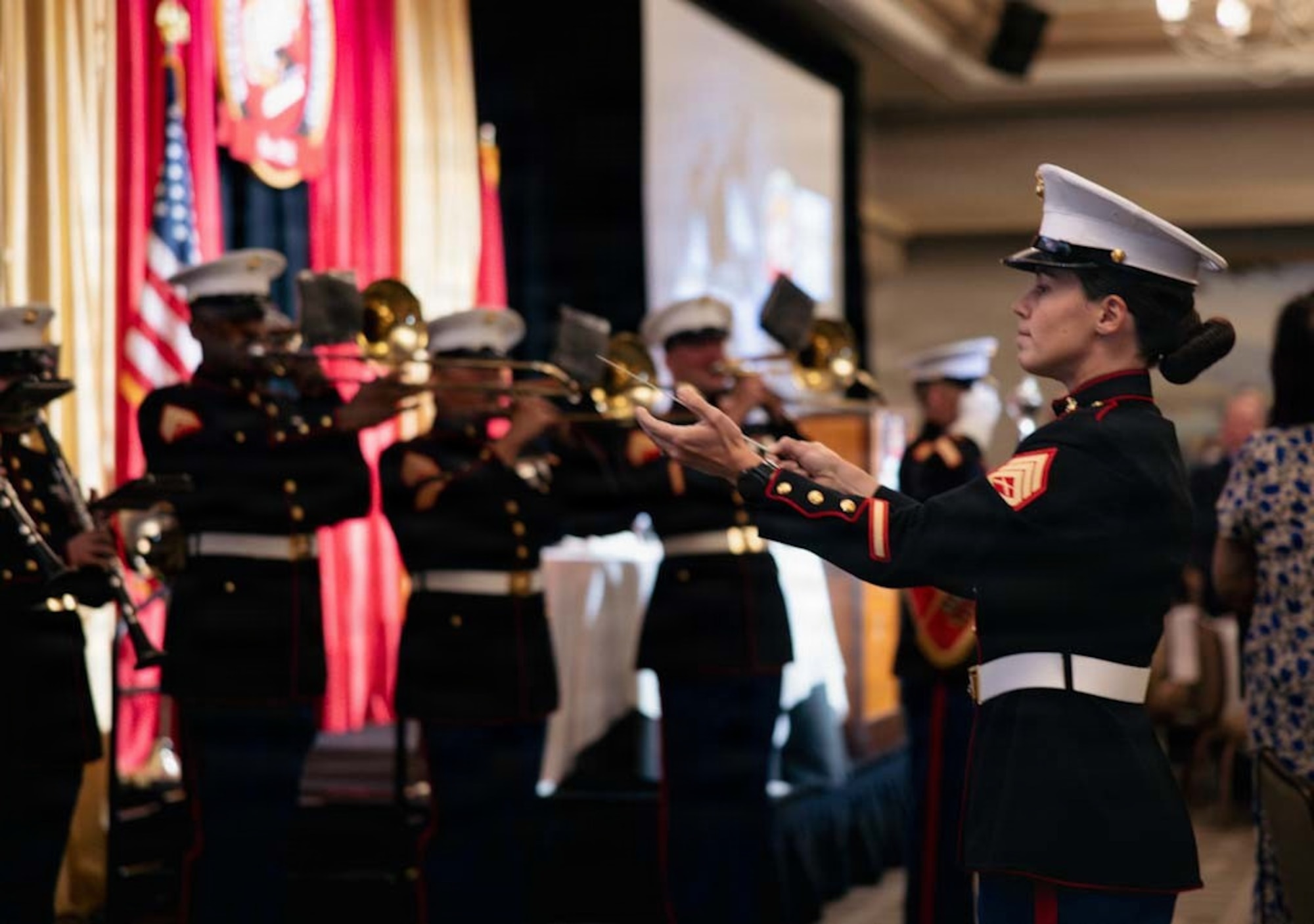 U.S. Marine Corps Staff Sgt. Hannah Ford, a musician with Marine Band San Diego, conducts the band during the Patriots at Pebble, Eagle, Globe and Anchor Dinner at Pebble Beach, California, March 1, 2026. The Patriots at Pebble event has been hosted by the Marine Corps Scholarship Foundation since 1962. The Foundation has provided over 31,000 scholarships, valuing over $235 million dollars. Marine Band San Diego performs a wide variety of music at military ceremonies and civilian events throughout the Western Recruiting Region. (U.S. Marine Corps photo by Lance Cpl. Brooke Pedersen)