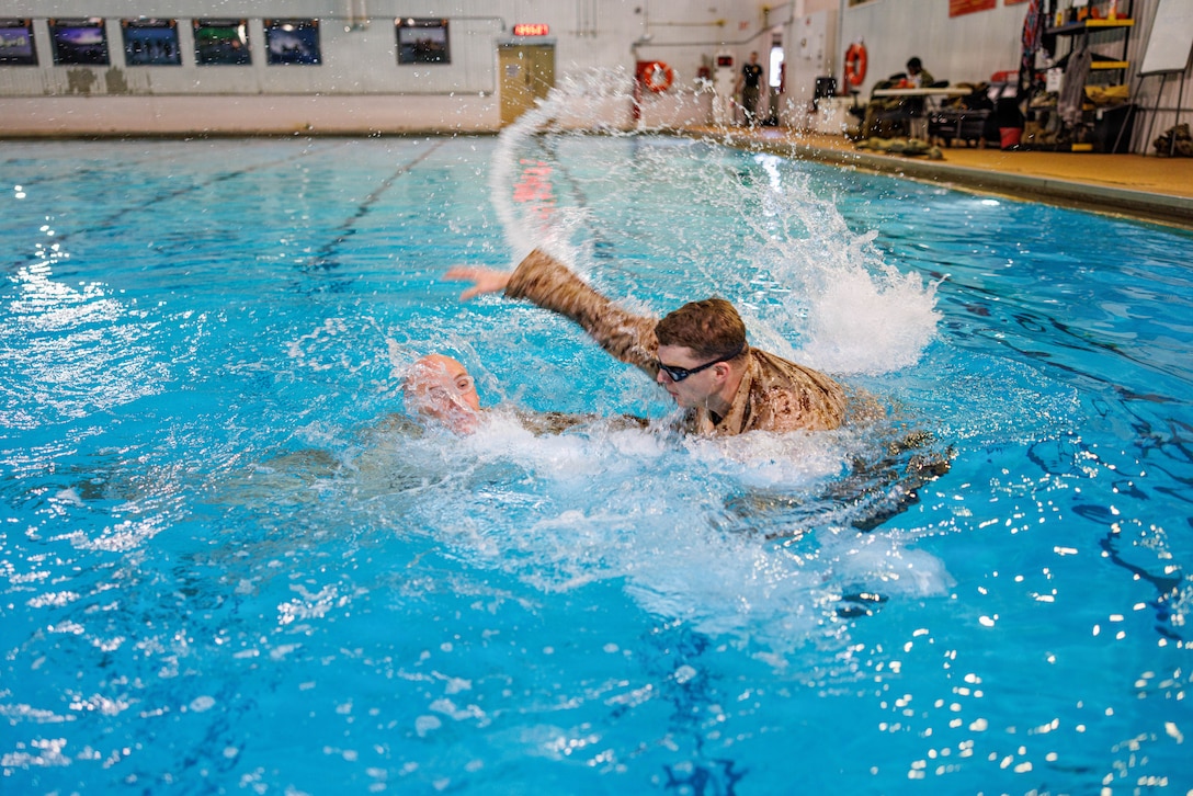 U.S. Marine Corps Sgt. John J. Davis, right, a Marine Corps Instructor of Water Survival with The Basic School, acts as a simulated victim for 2nd Lt. Grant A. Wernick, a student with The Basic School, during a water rescue swim for the Water Survival Advanced Course at Ramer Hall on Marine Corps Base Quantico, Virginia, Jan. 22, 2026. The week-long Water Survival Advanced course challenges Marines’ physical and mental limits through aquatic endurance training, including long swims, breath holds, and complex rescue drills vital to amphibious operations. (U.S. Marine Corps photo by Lance Cpl. Donovan E. Melendez)