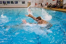 U.S. Marine Corps Sgt. John J. Davis, right, a Marine Corps Instructor of Water Survival with The Basic School, acts as a simulated victim for 2nd Lt. Grant A. Wernick, a student with The Basic School, during a water rescue swim for the Water Survival Advanced Course at Ramer Hall on Marine Corps Base Quantico, Virginia, Jan. 22, 2026. The week-long Water Survival Advanced course challenges Marines’ physical and mental limits through aquatic endurance training, including long swims, breath holds, and complex rescue drills vital to amphibious operations. (U.S. Marine Corps photo by Lance Cpl. Donovan E. Melendez)