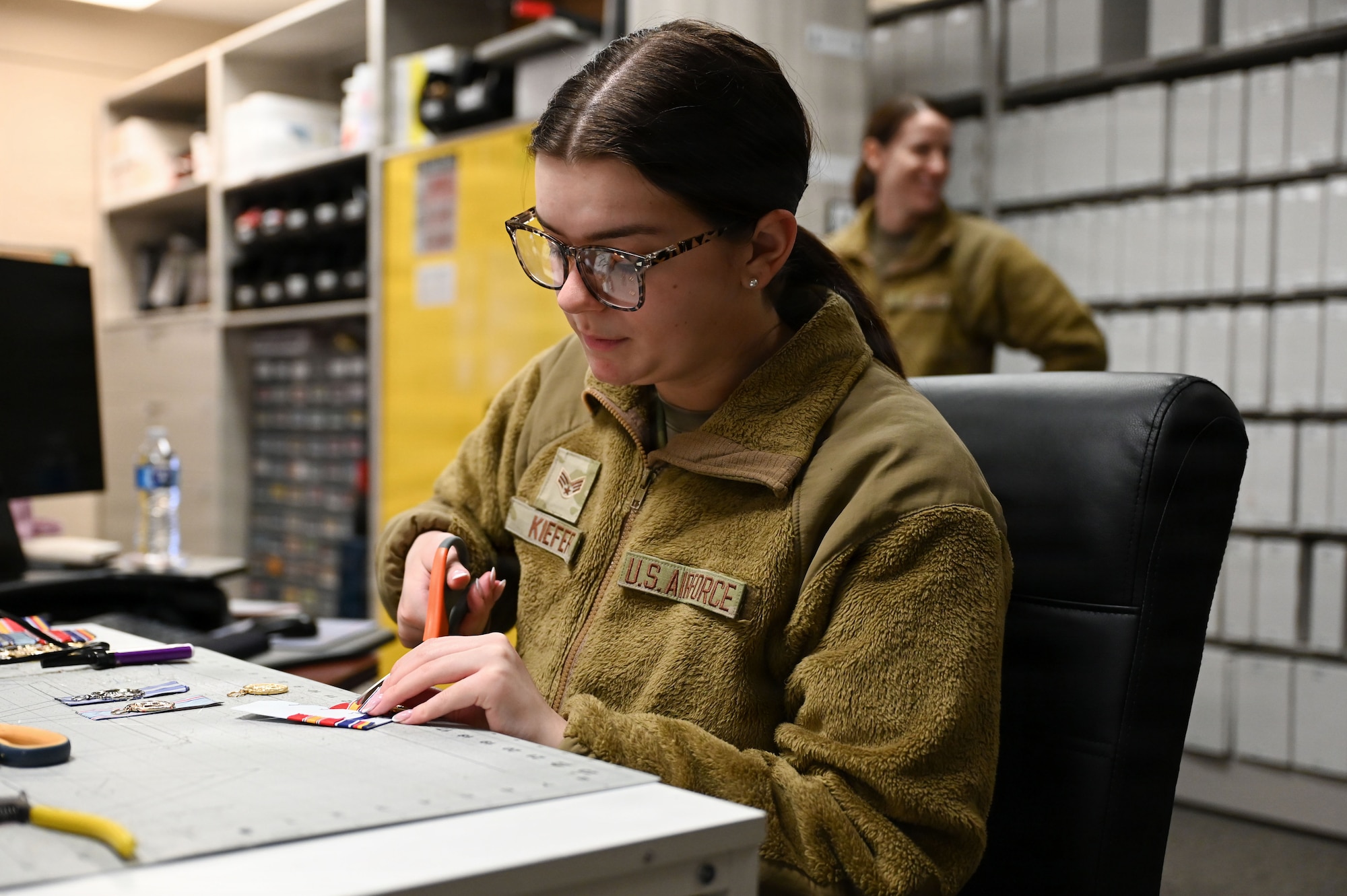 U.S. Air Force Senior Airman Skylar Kiefer, a supply technician with the U.S. Air Force Honor Guard Supply, trims excess fabric off a medal at Joint Base Anacostia-Bolling, Washington, D.C., March 4, 2026. Established to support the U.S. Air Force Honor Guard, the Honor Guard Supply section has the second largest flag room in the Department of War. (U.S. Air Force photo by Airman 1st Class Brandon Thomas)
