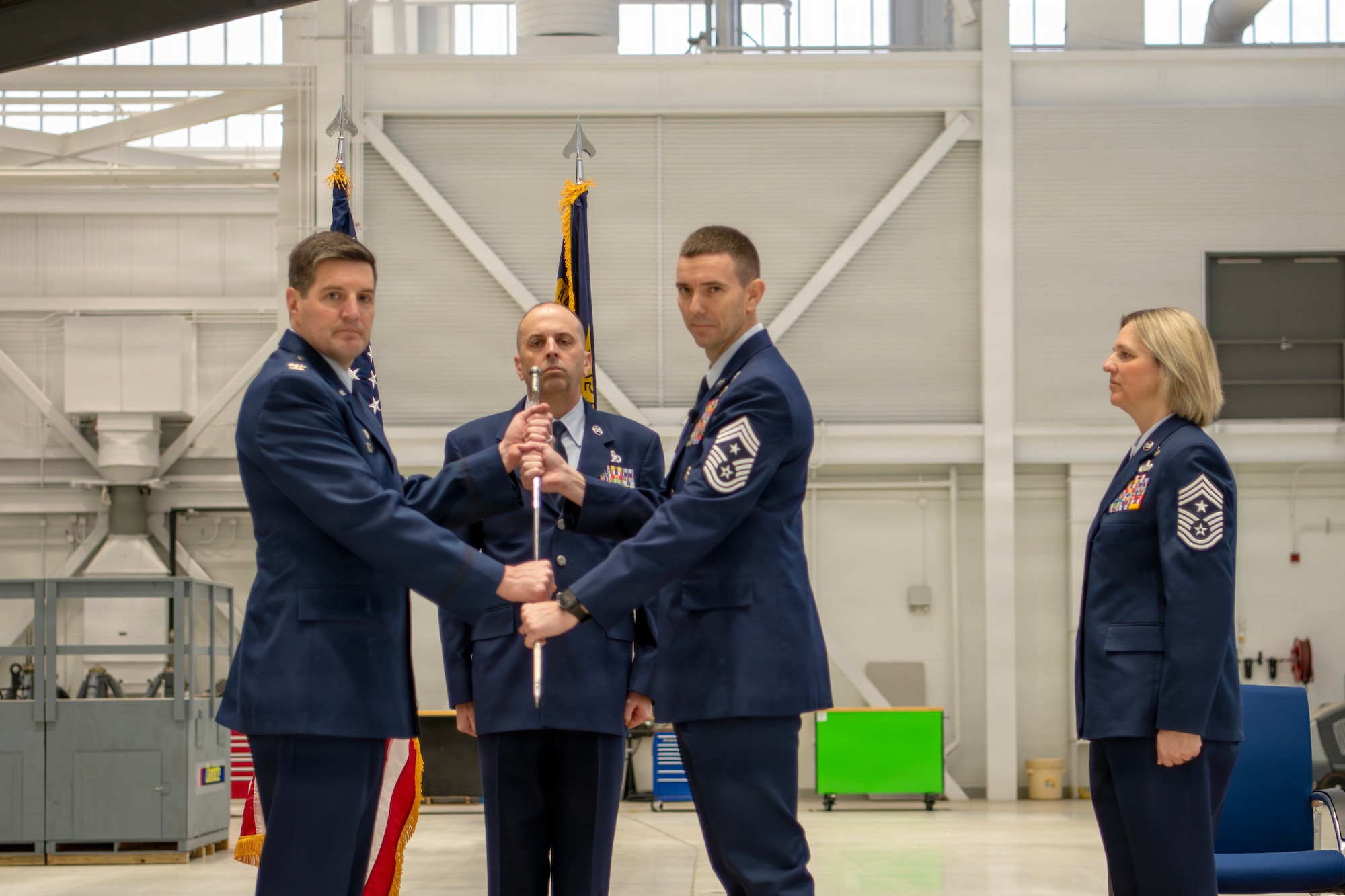 U.S. Air Force Col. Marshal T. Haylett, 145th Airlift Wing (AW) commander, left, receives a ceremonial sword from Chief Master Sgt. Jeremy S. Mullins, right, as he relinquishes responsibility as the 145th AW command chief at a change of responsibility ceremony held at the Charlotte Air National Guard base, Feb. 27, 2026.