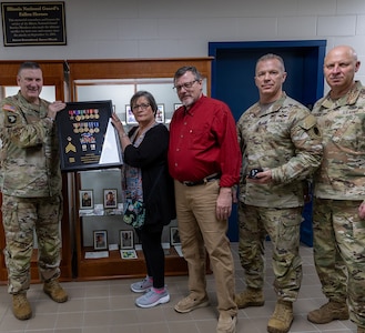 Brig. Gen. Lenny Williams, Assistant Adjutant General – Army and Commander of the Illinois Army National Guard, presents Sue King-Wieczorek, Gold Star mother of U.S. Army Sgt. Robert M. Weinger, with a shadow box containing Weinger’s medals he earned during his military service in the Illinois Army National Guard.