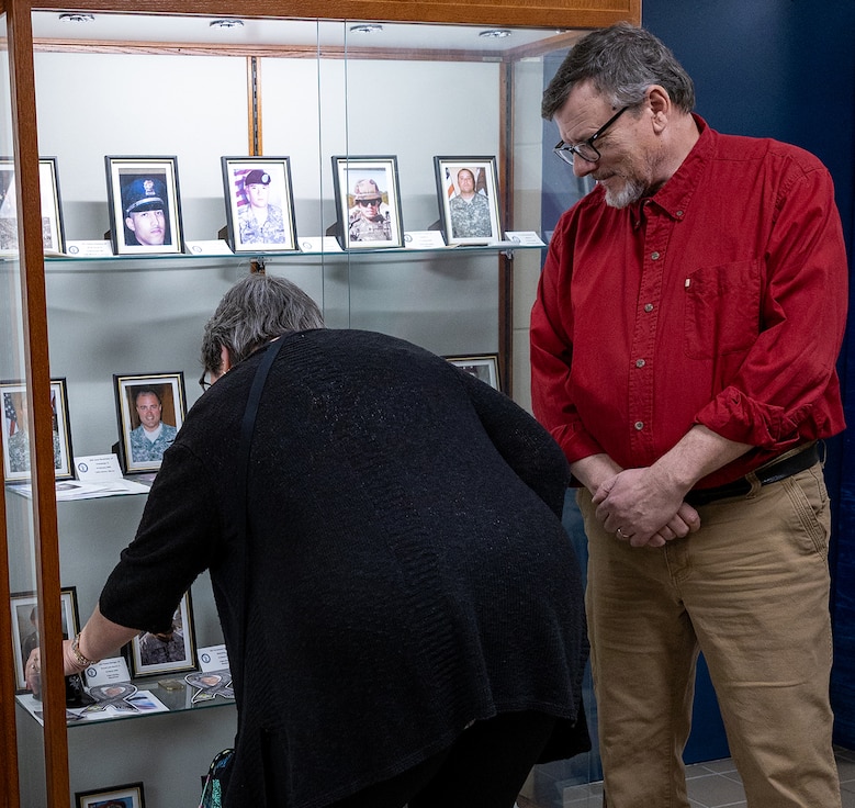Sue King-Wieczorek, the Gold Star mother of Army Sgt. Robert M. Weinger, places the Chicago White Sox mini helmet in the memorial display case March 6 at the Illinois Military Academy on Camp Lincoln in Springfield. For King-Wieczorek, the mini helmet is a remembrance of an afternoon spent at the ballpark with Weinger before his Illinois Army National Guard unit deployed to Afghanistan.