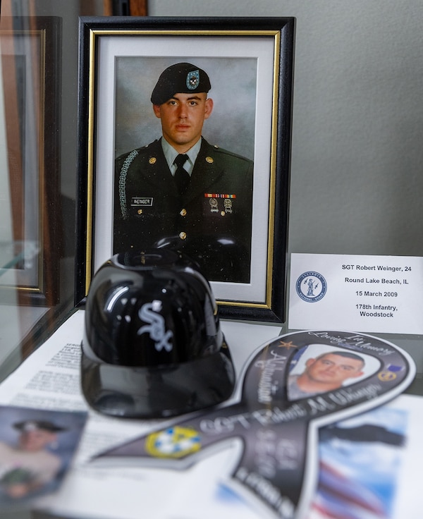 The Chicago White Sox provided a replacement mini helmet for Gold Star mother Sue King-Wieczorek to place among the mementos in a memorial case at the Illinois Military Academy on Camp Lincoln in Springfield honoring the 34 Illinois National Guard service members who have died in service to the country since the terrorist attacks of Sept. 11, 2001.