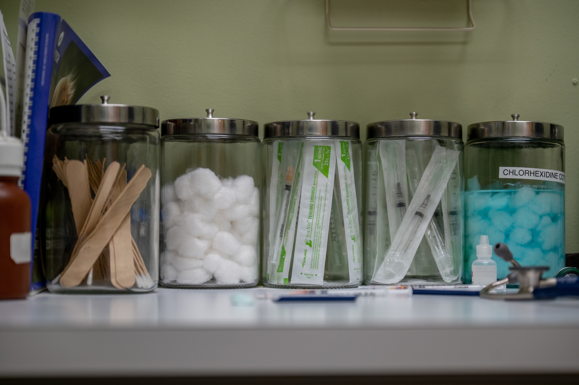 Various jars filled with medical equipment sit on a counter.