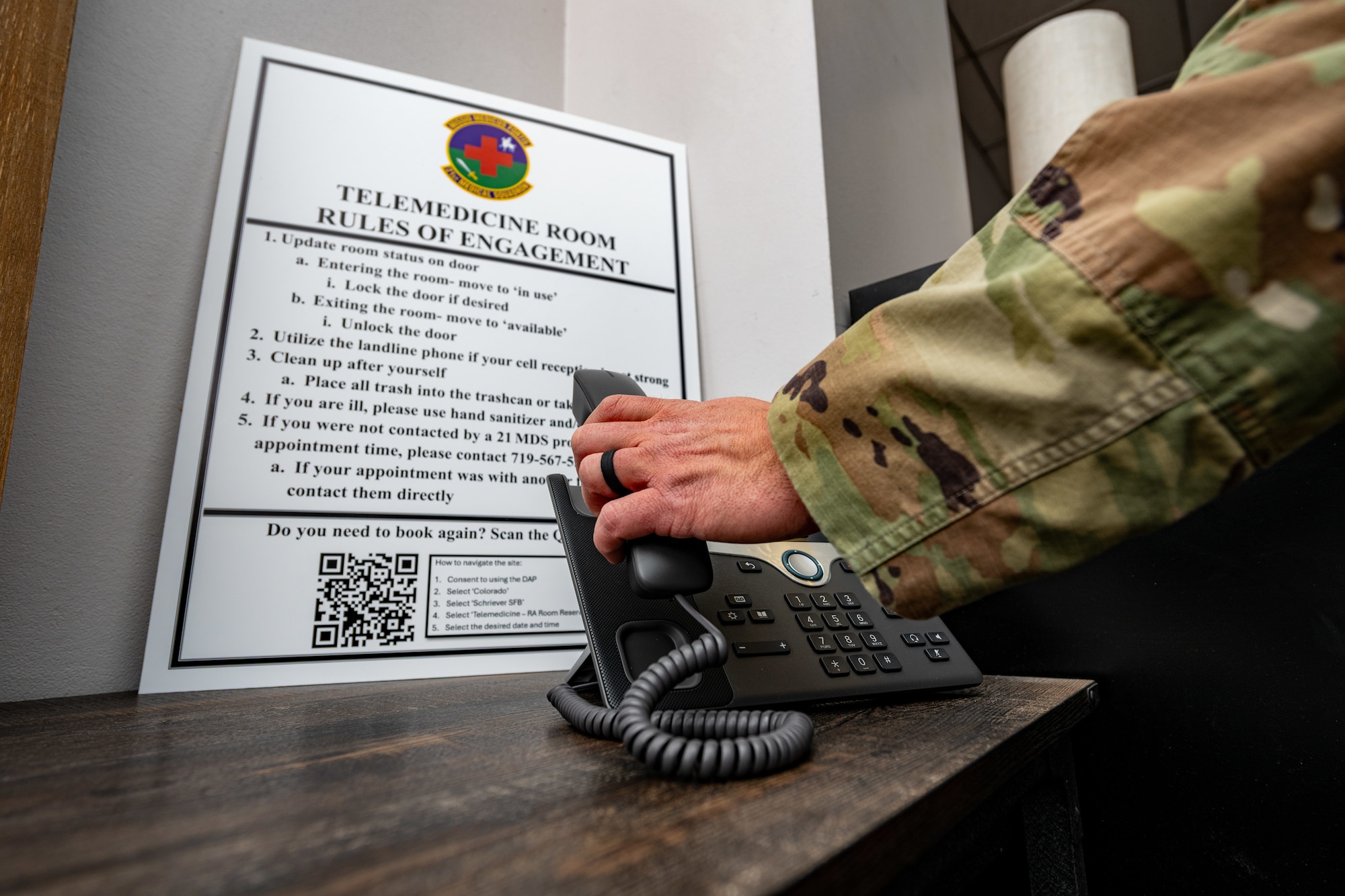 A photo of an Airman picking up a telephone at Schriever SFB.