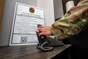 A photo of an Airman picking up a telephone at Schriever SFB.