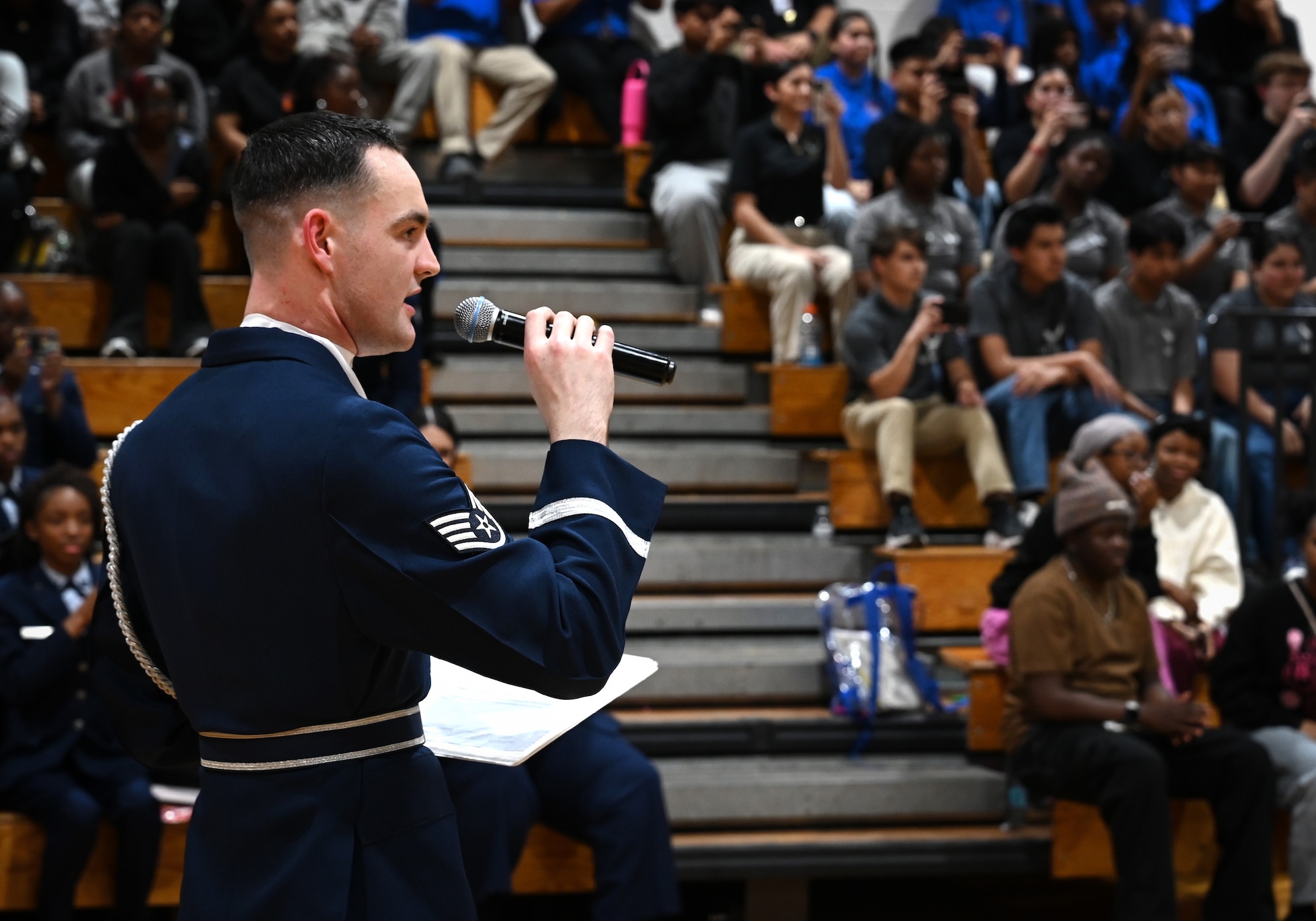 U.S. Air Force Staff Sgt. William Douglas, ceremonial guardsman with the U.S. Air Force Honor Guard Drill Team, emcees a performance during a visit to Ronald McNair Sr. High School in Atlanta, Ga., March 11, 2026. During the event, the Drill Team worked with local recruiters and high schools to emphasize the Air Force mission and inspire the future generation of service members. (U.S. Air Force photo by Tech. Sgt. Sergio A. Gamboa)