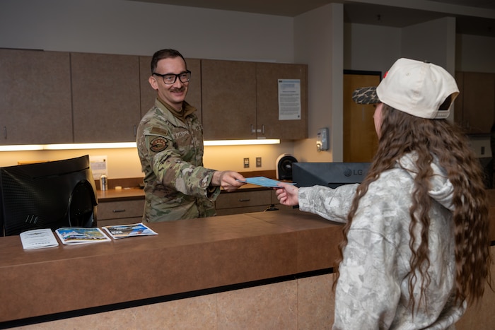 A U.S. Air Force Airman provides a Blue Envelope to a Schriever Space Force Base visitor at the base visitor’s center at Schriever Space Force Base.