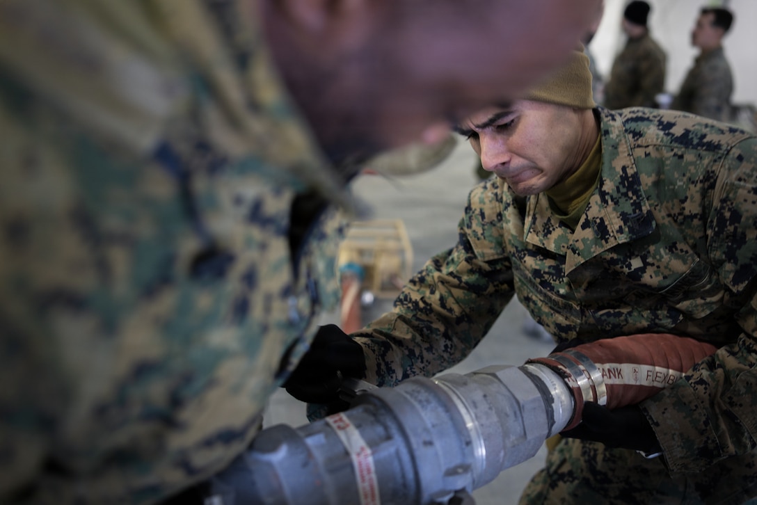 U.S. Marine Corps Cpl. Brian Alvarez-Bolay, right, and Cpl. Njomen Usmanjuniorabdulahi, both expeditionary fuels technicians with 6th Engineer Support Battalion, 4th Marine Logistics Group, Marine Forces Reserve, lock a four-foot dry-break suction hose in Elvegårdsmoen, Norway, Feb. 26, 2026. The equipment was being prepared for exercise Cold Response 26. A key component of NATO's enhanced vigilance activity Arctic Sentry, exercise Cold Response 26 is a Norwegian-led winter military exercise designed to enhance collective defense capabilities and ensure U.S. readiness to rapidly deploy and seamlessly operate alongside NATO Allies in challenging arctic conditions. (U.S. Marine Corps photo by Staff Sgt. Scott Jenkins)