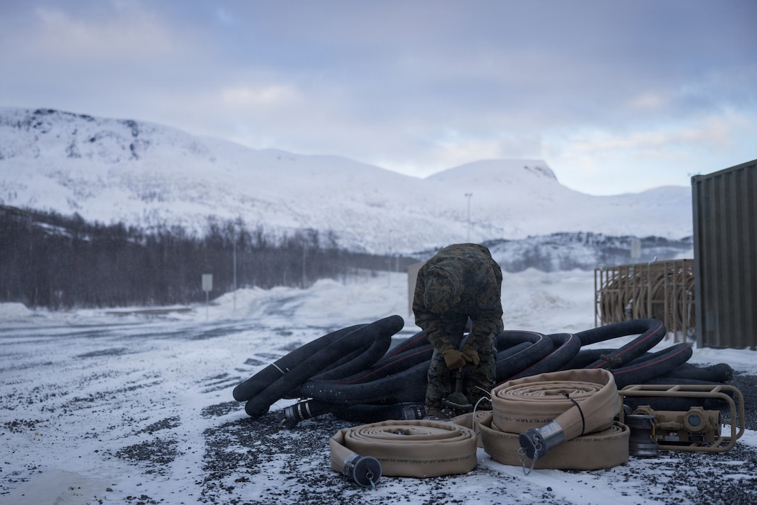 U.S. Marine Corps Cpl. Brian Alvarez-Bolay, an expeditionary fuels technician with 6th Engineer Support Battalion, 4th Marine Logistics Group, Marine Forces Reserve, organizes bulk fuel equipment in Elvegårdsmoen, Norway, Feb. 26, 2026. The equipment was being organized in preparation for exercise Cold Response 26. A key component of NATO's enhanced vigilance activity Arctic Sentry, exercise Cold Response 26 is a Norwegian-led winter military exercise designed to enhance collective defense capabilities and ensure U.S. readiness to rapidly deploy and seamlessly operate alongside NATO Allies in challenging arctic conditions. (U.S. Marine Corps photo by Staff Sgt. Scott Jenkins)
