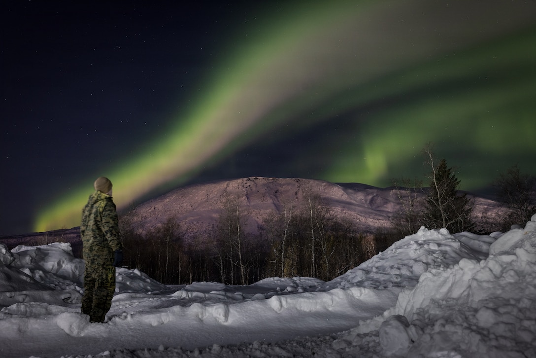 U.S. Marine Corps Cpl. Isaiah Smith, a combat videographer with Headquarters Battalion, Marine Forces Reserve, observes the northern lights in Elvegårdsmoen, Norway, Feb. 23, 2026. The Marine was deployed to Norway in preparation for exercise Cold Response 26. A key component of NATO's enhanced vigilance activity Arctic Sentry, exercise Cold Response 26 is a Norwegian-led winter military exercise designed to enhance collective defense capabilities and ensure U.S. readiness to rapidly deploy and seamlessly operate alongside NATO Allies in challenging arctic conditions. (U.S. Marine Corps photo by Staff Sgt. Scott Jenkins)