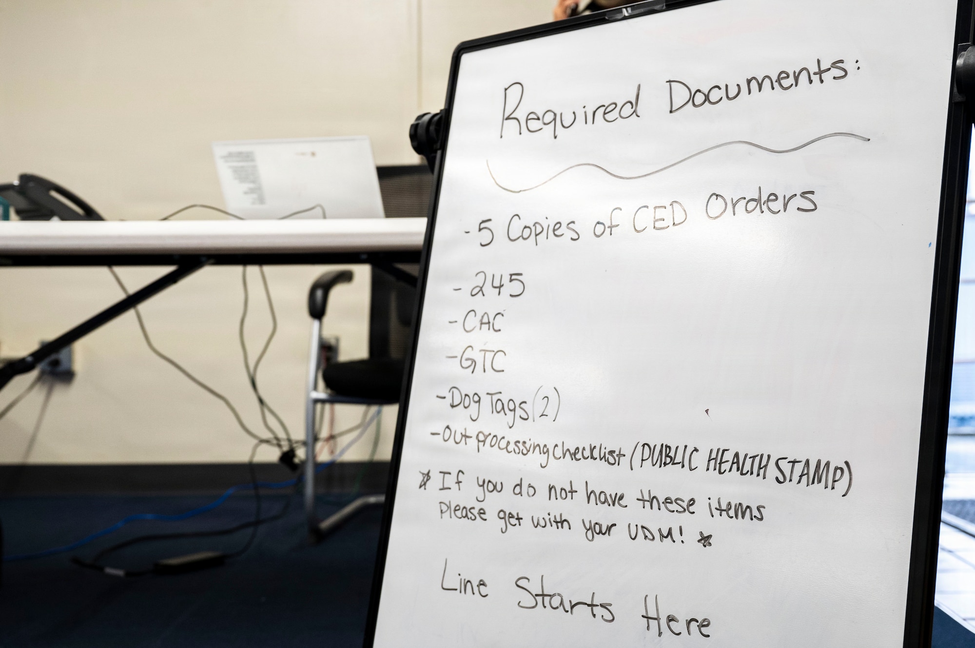 A whiteboard outlining required documents for a simulated personnel deployment line stands during U.S. Air Force-led operational exercise Beverly Midnight 26 at Kadena Air Base, Japan, March 11, 2026.