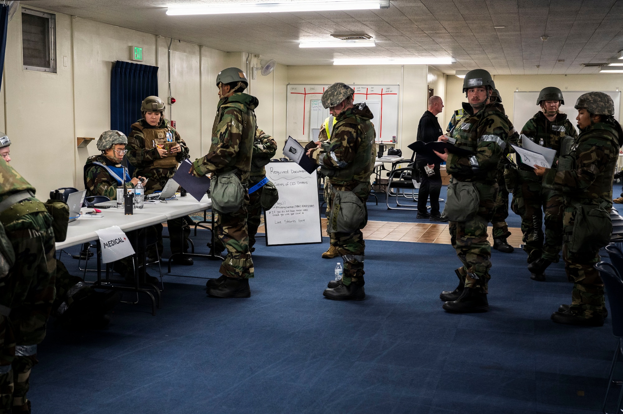 Members of the 18th Wing sign in during a simulated personnel deployment line as part of U.S. Air Force-led operational exercise Beverly Midnight 26 at Kadena Air Base, Japan, March 11, 2026.