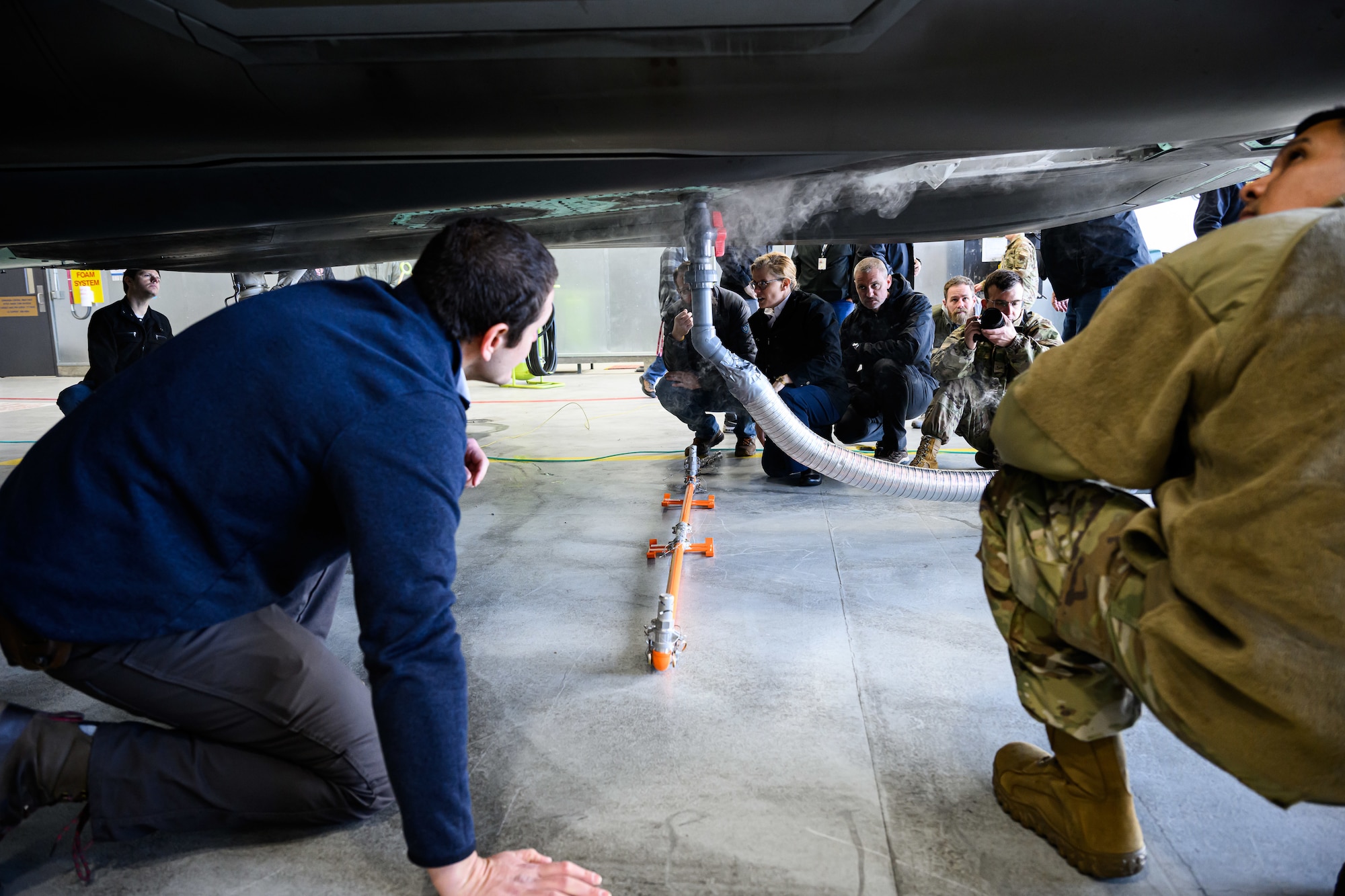 A photograph of firefighters training to extinguish battery fires on an F-35