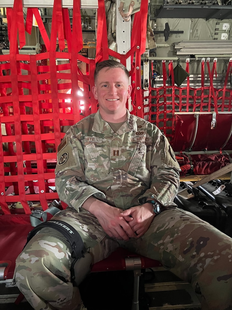 A man seated in a cargo aircraft seat
