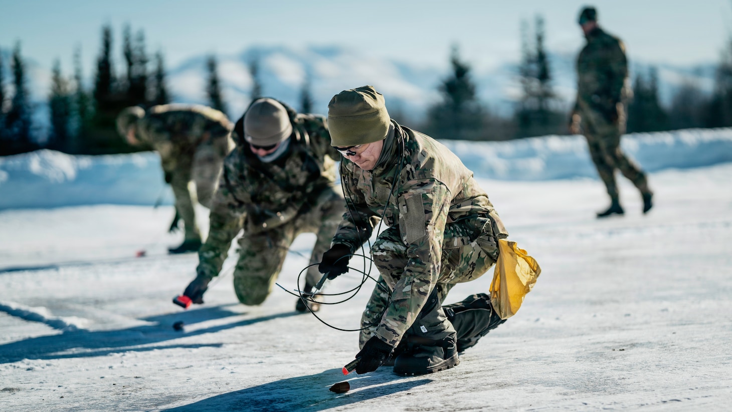 U.S. Navy Explosive Ordnance Disposal technicians assigned to Explosive Ordnance Disposal Mobile Unit ELEVEN (EODMU-11) and a U.S. Air Force EOD technician assigned to the 673rd Expeditionary Civil Engineer Squadron arm and lay C4 on submunitions for an airfield clearance drill during ARCTIC EDGE 2026 (AE26) at Joint Base Elmendorf-Richardson, Alaska, March 5, 2026. AE26 is a North American Aerospace Defense Command (NORAD) and U.S. Northern Command-led Homeland defense exercise designed to improve readiness, demonstrate capabilities, and enhance Joint and Allied Force interoperability in the Arctic. (U.S. Navy photo by Mass Communication Specialist 2nd Class August Clawson)