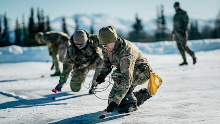 U.S. Navy Explosive Ordnance Disposal technicians assigned to Explosive Ordnance Disposal Mobile Unit ELEVEN (EODMU-11) and a U.S. Air Force EOD technician assigned to the 673rd Expeditionary Civil Engineer Squadron arm and lay C4 on submunitions for an airfield clearance drill during ARCTIC EDGE 2026 (AE26) at Joint Base Elmendorf-Richardson, Alaska, March 5, 2026. AE26 is a North American Aerospace Defense Command (NORAD) and U.S. Northern Command-led Homeland defense exercise designed to improve readiness, demonstrate capabilities, and enhance Joint and Allied Force interoperability in the Arctic. (U.S. Navy photo by Mass Communication Specialist 2nd Class August Clawson)