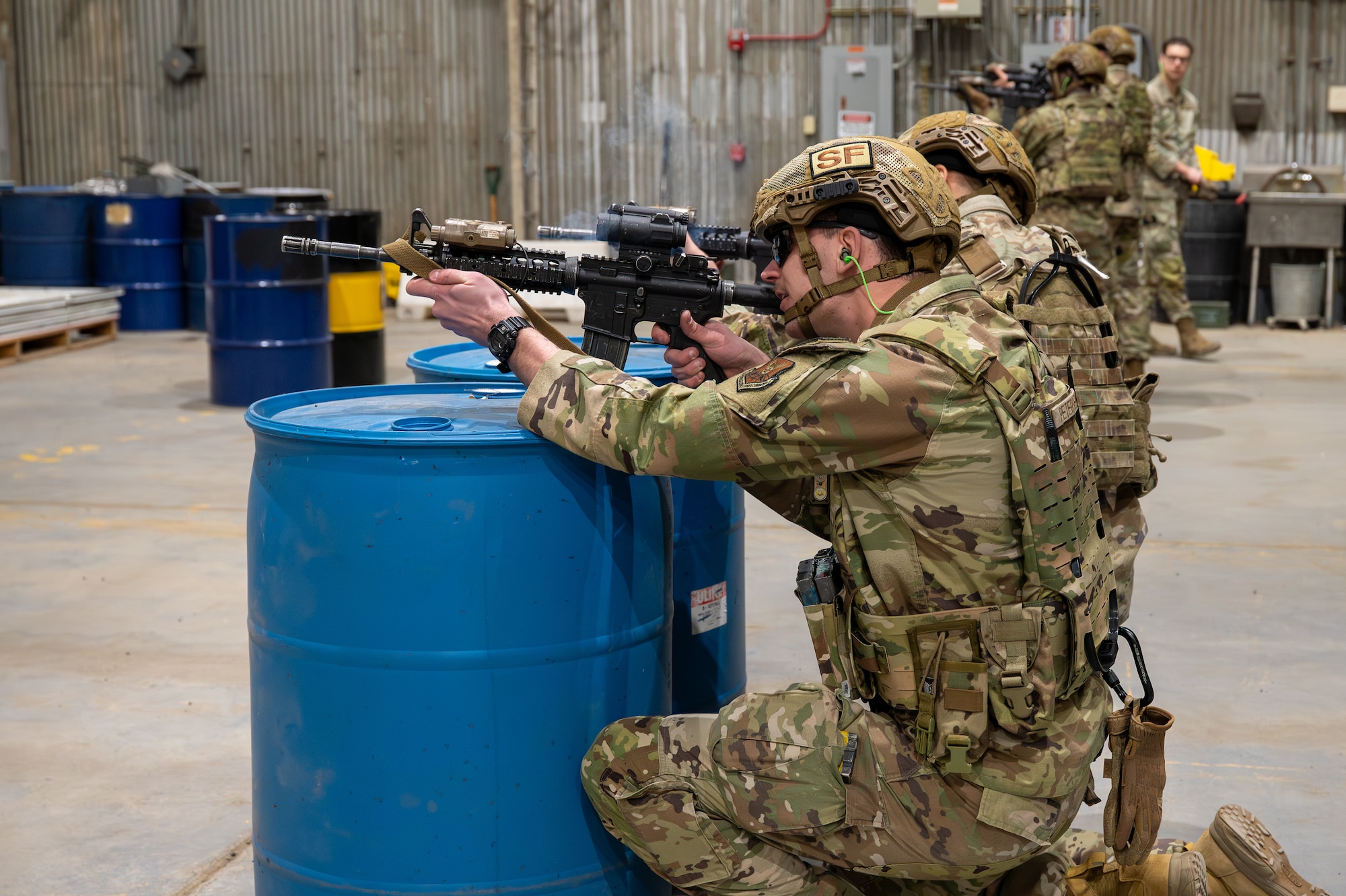 A uniformed man aims an M4 rifle.