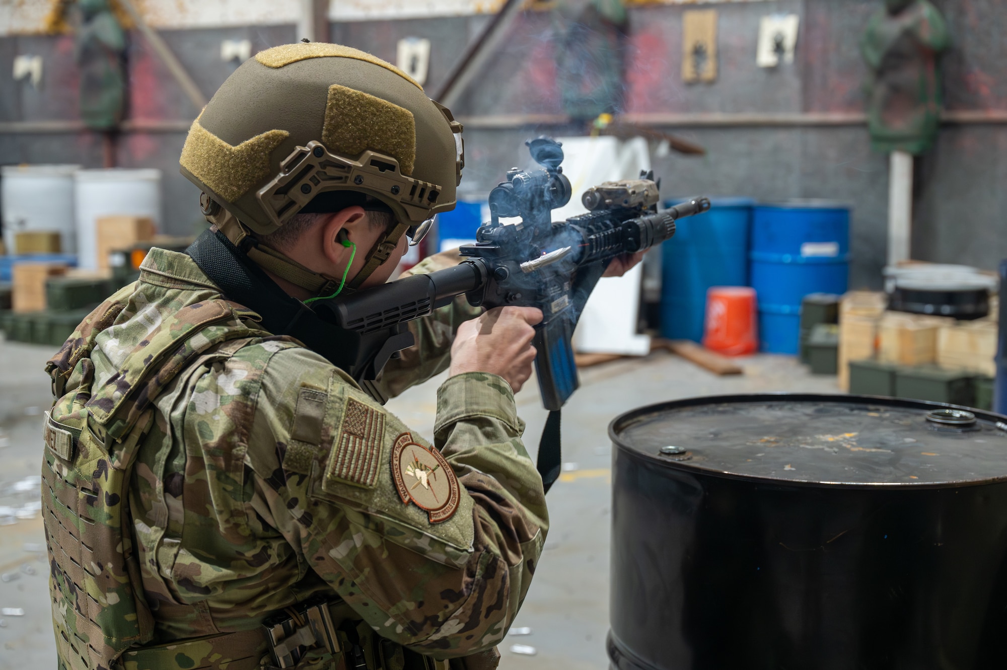 A uniformed man aims an M4 rifle.